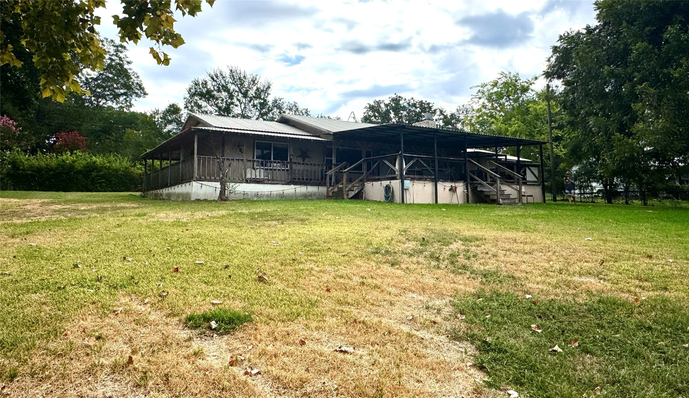 Expansive lot featuring mature trees, a covered porch, and a multi-level deck