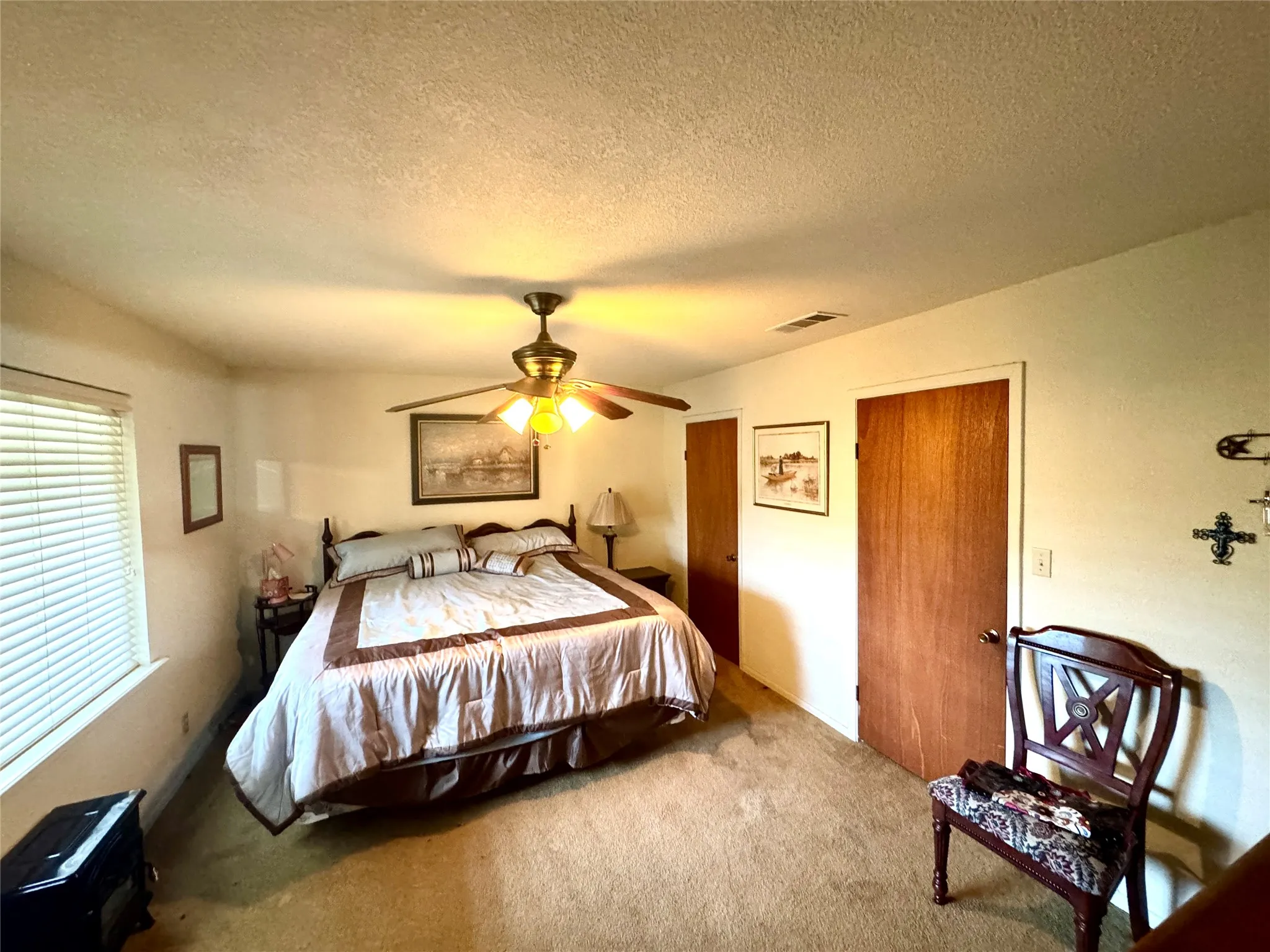 Carpeting throughout, ceiling-mounted fan with integrated lighting, wood-finish interior doors, and window with horizontal blinds