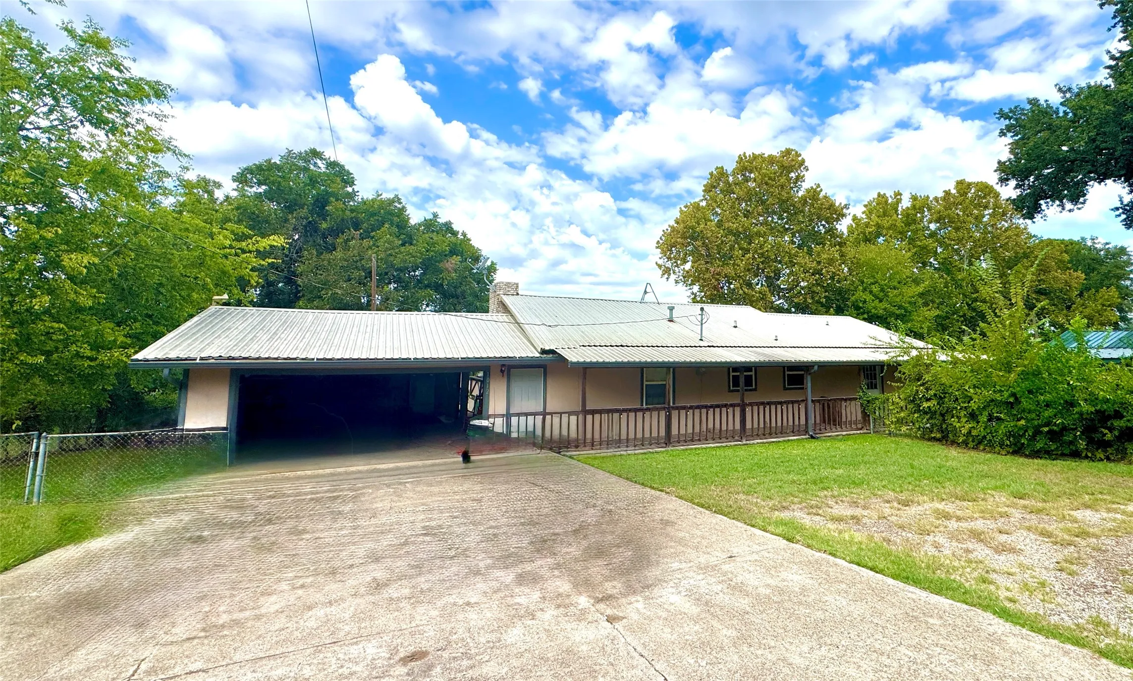 Extended driveway leading to a covered carport