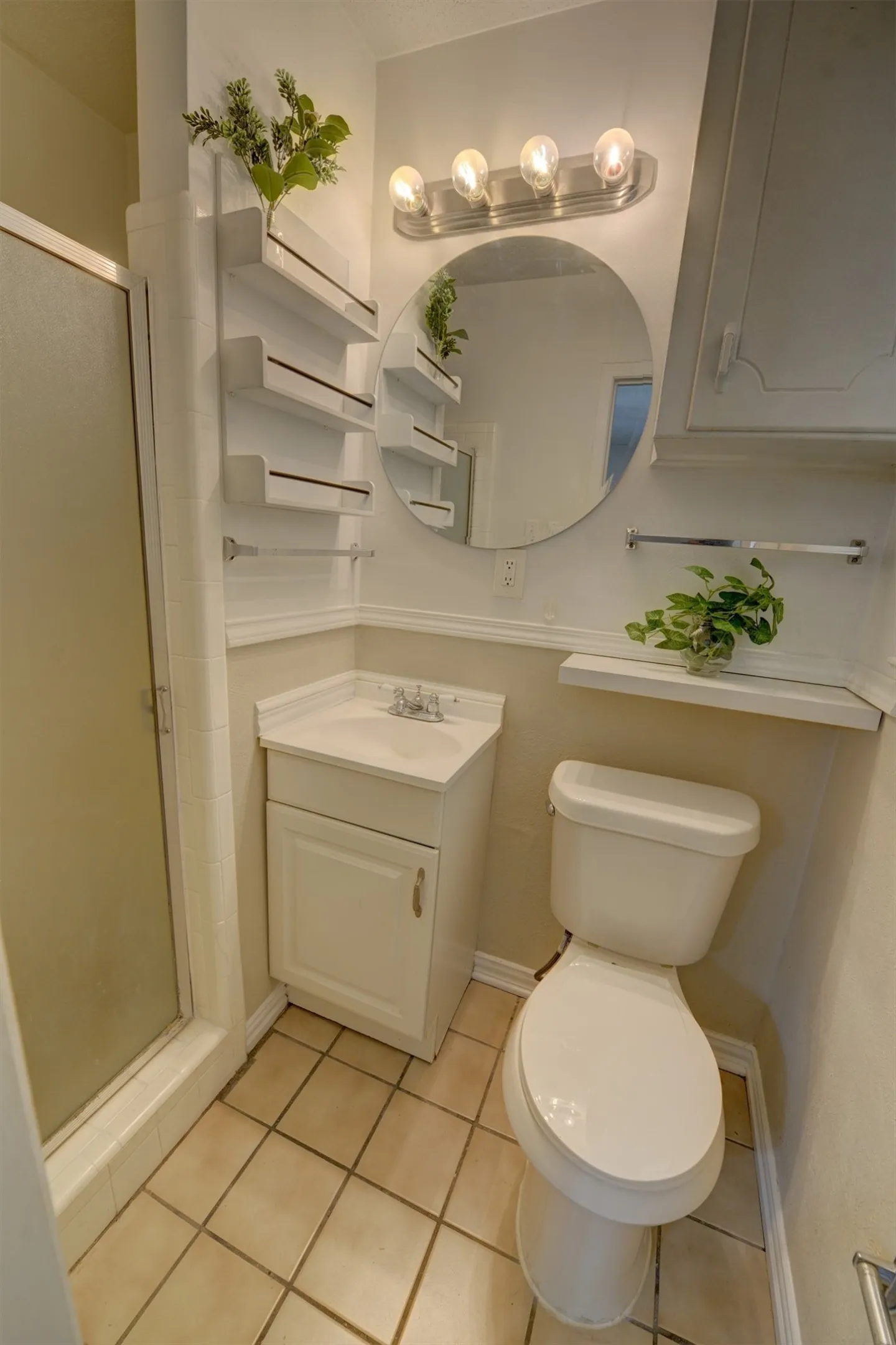 White corner vanity with an integrated sink, polished chrome faucet, and tile flooring