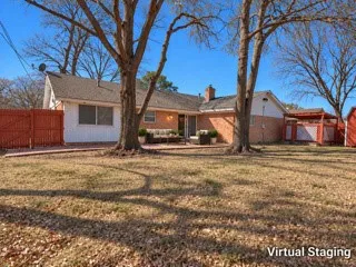 Expansive backyard featuring mature trees, a brick-paved patio, and a red wood fence