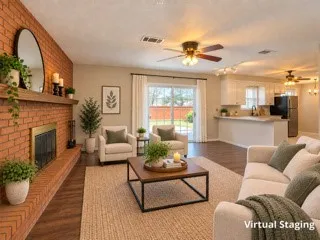 Brick fireplace with a wood-mantel, wood-finish flooring, sliding glass door, ceiling fans, and a kitchen with white cabinetry