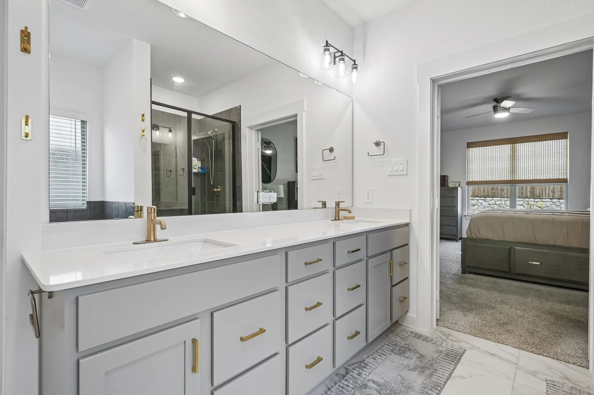Dual vanity with white countertop and gold-finish fixtures