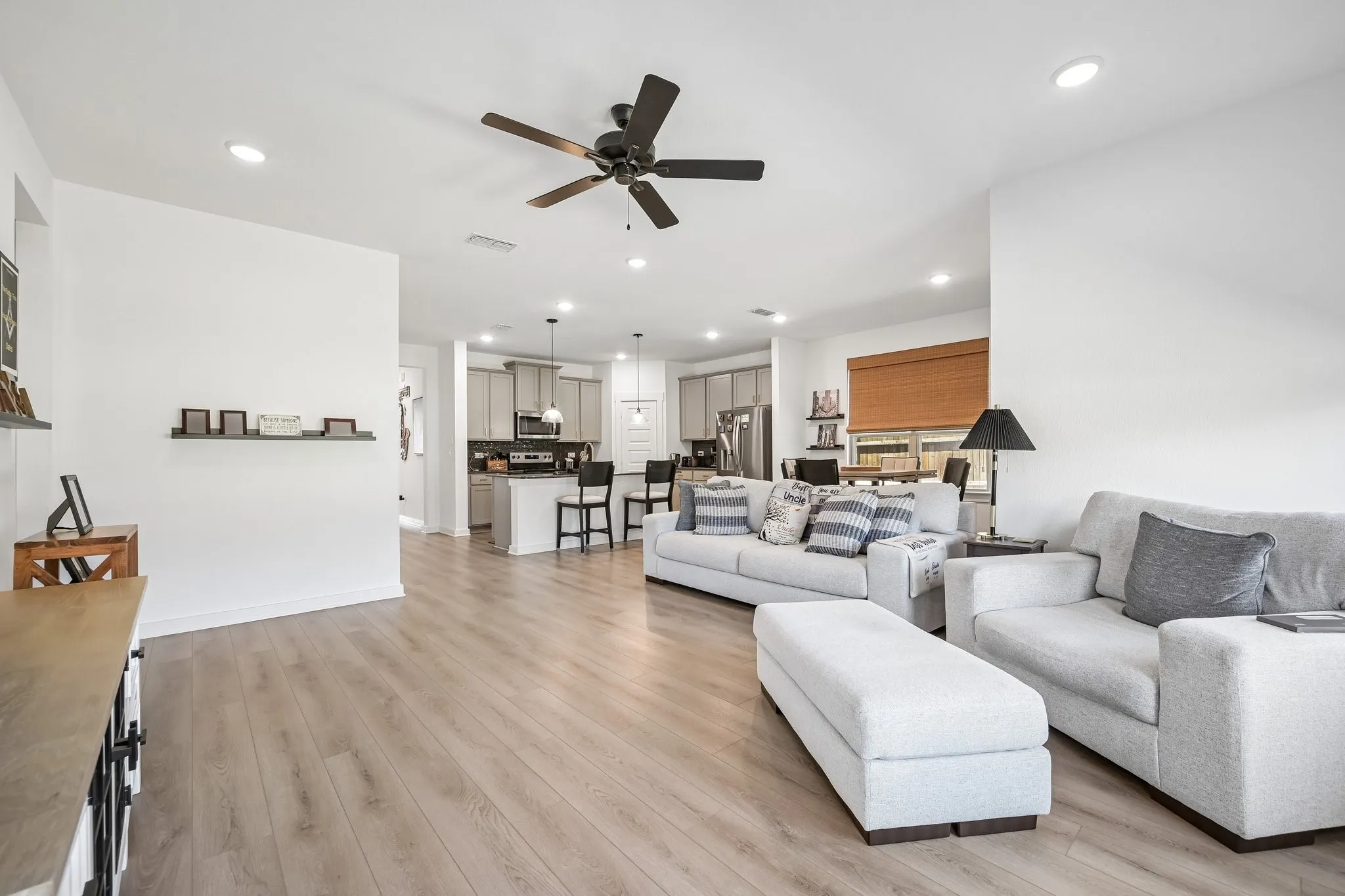 Wood-finish flooring, recessed lighting, and a ceiling fan create a comfortable atmosphere