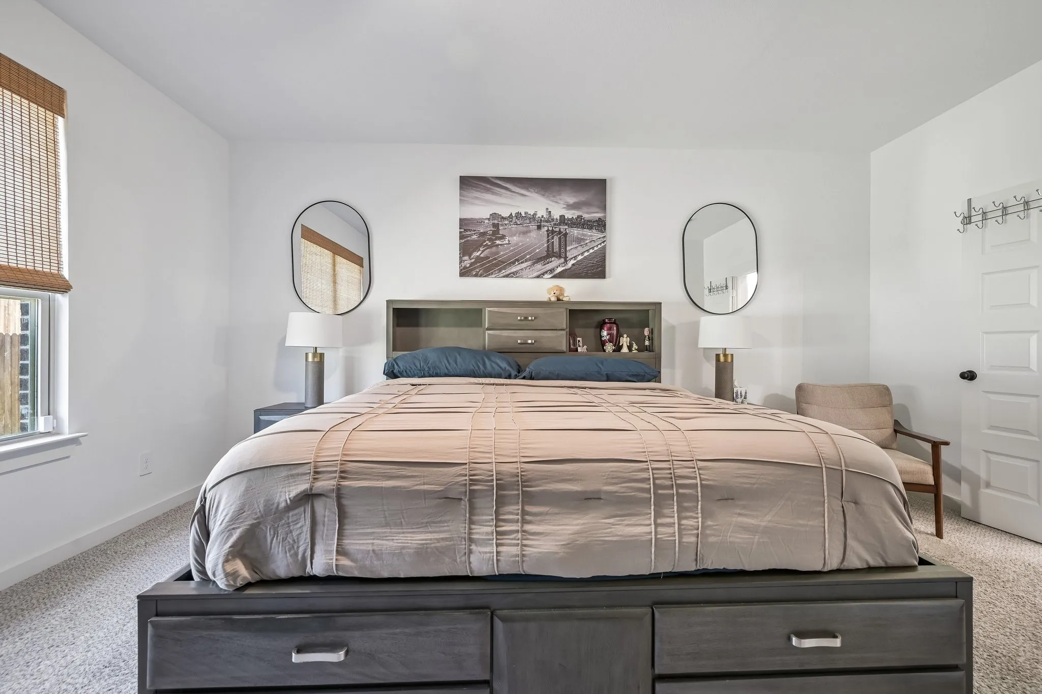 Carpeted flooring, white painted walls, and a window with a woven shade
