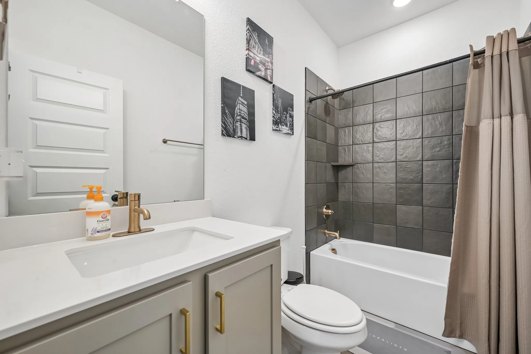 Single vanity with a white countertop and gold-finish faucet