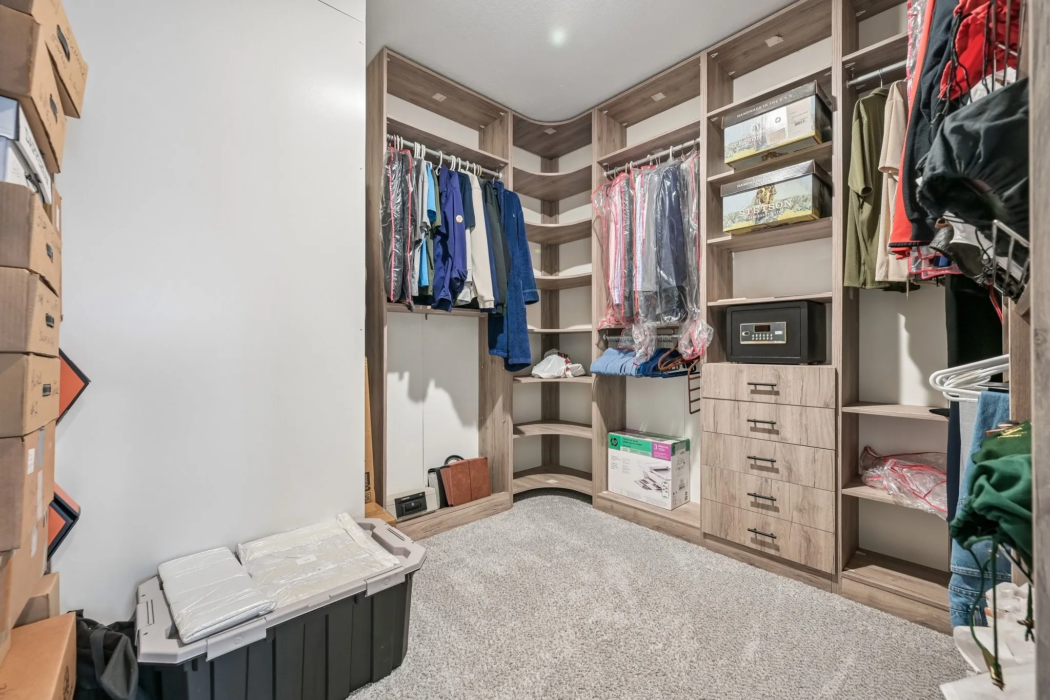 Custom closet system with wood-finish shelving, integrated drawers, and hanging rods