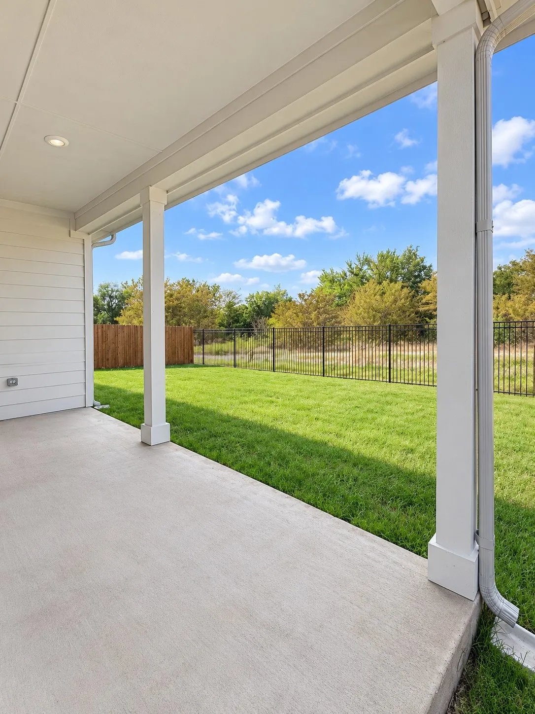 Covered patio with a concrete surface, recessed lighting, and white horizontal siding