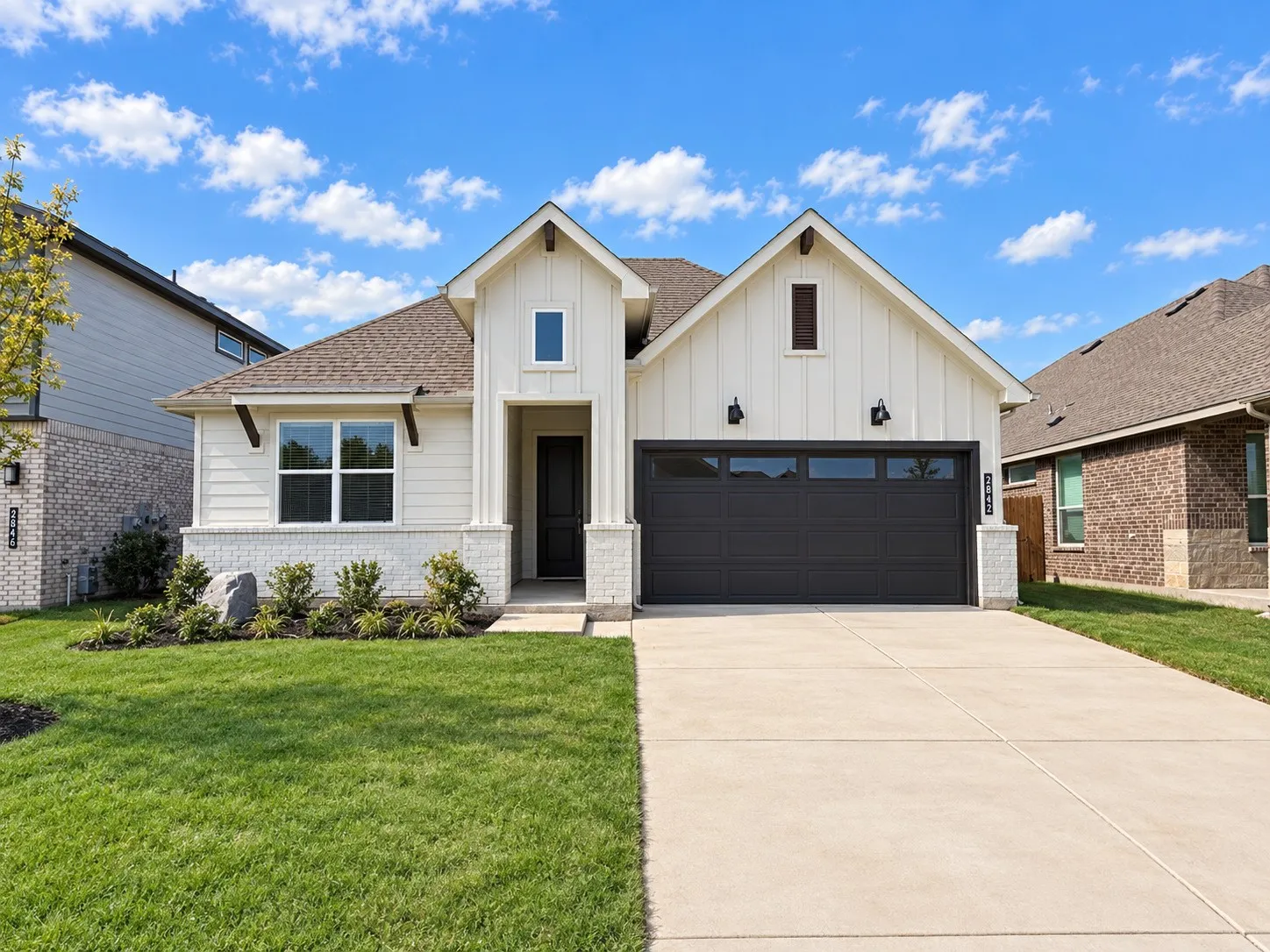 White siding exterior with a dark roof and white brick accent