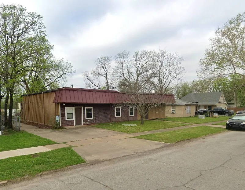 Brick and corrugated metal exterior with a red metal roof
