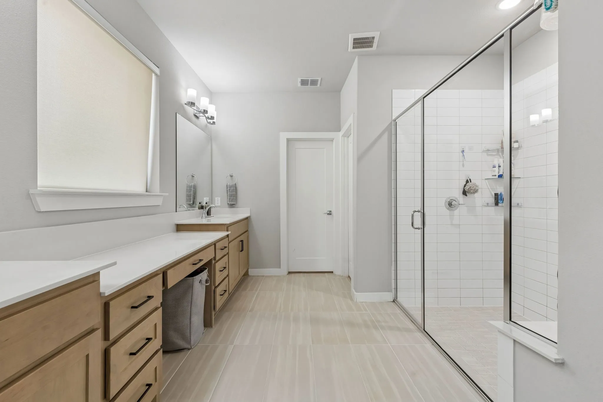 Dual vanity with ample counter space, built-in cabinetry, and integrated sinks