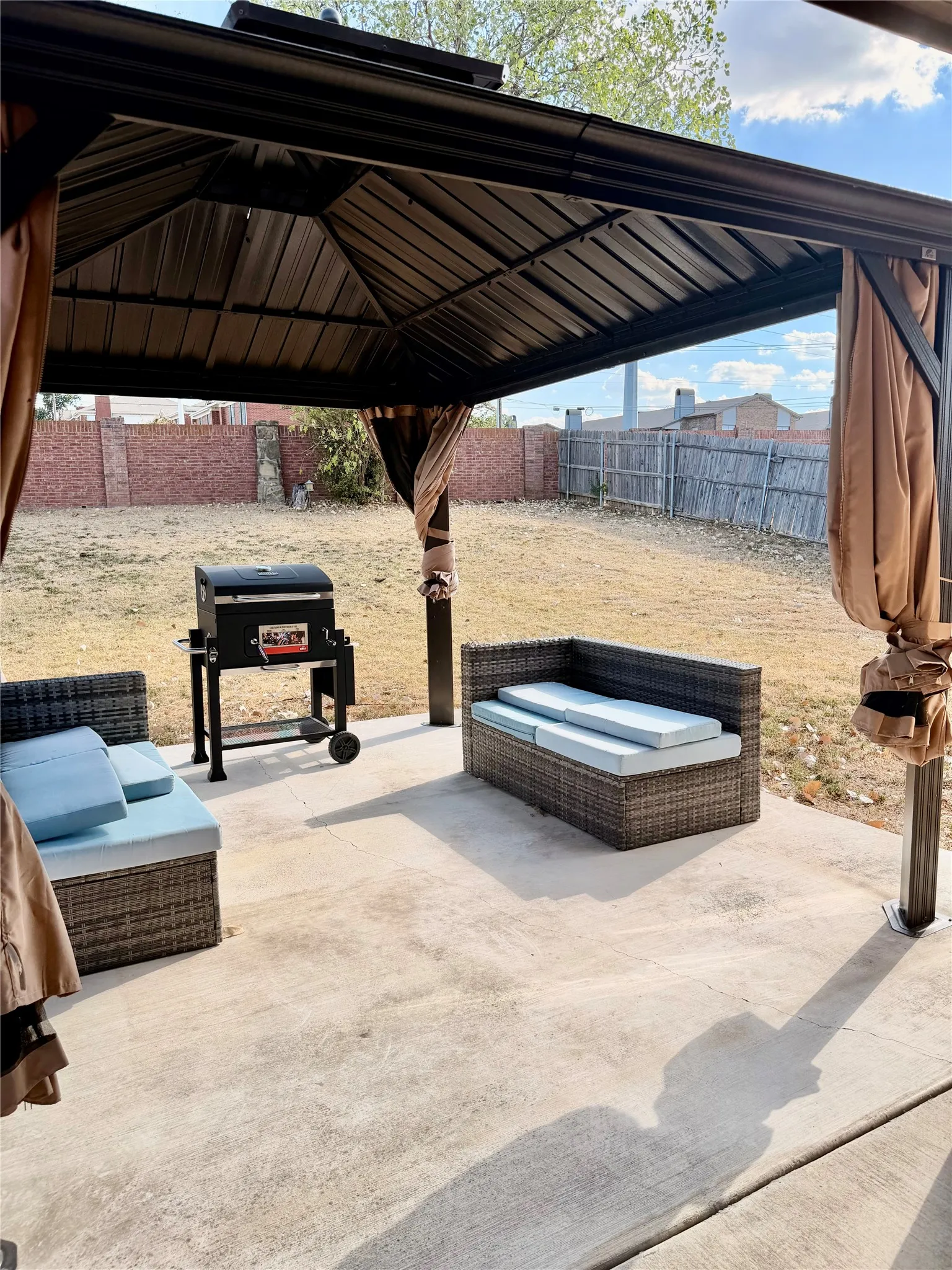 Concrete patio with an overhead metal gazebo structure