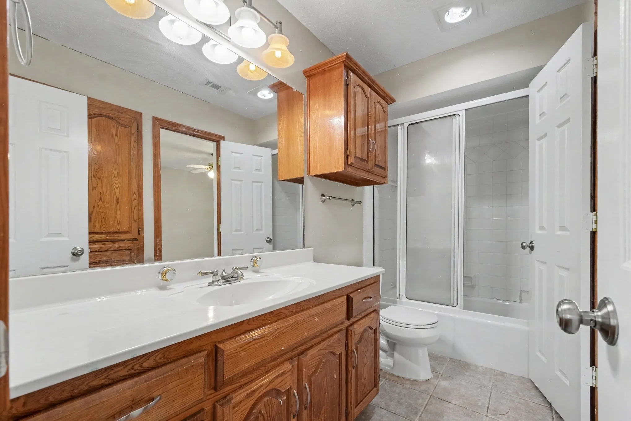 Wood-finish vanity with a white countertop and integrated sink