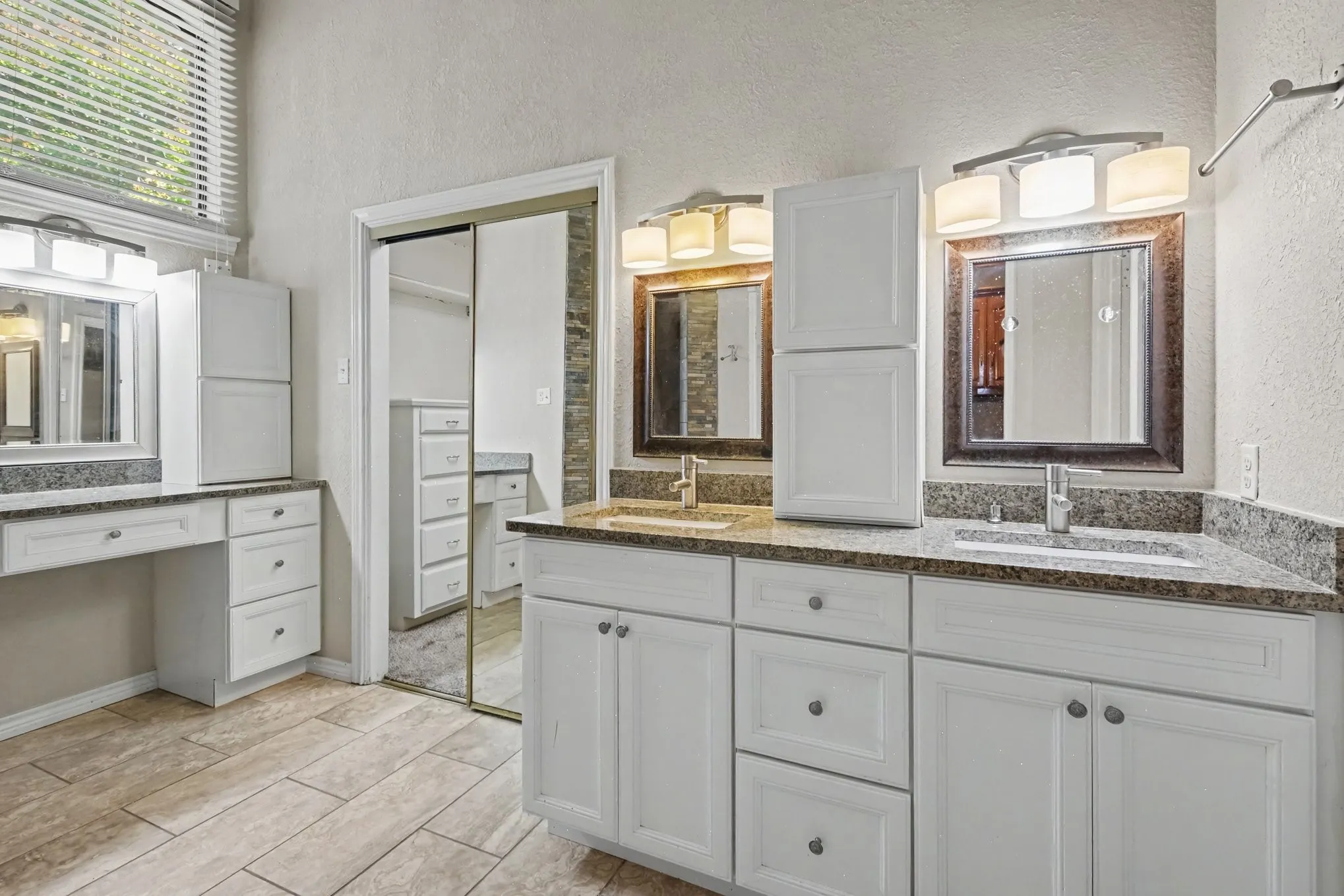Dual vanity with under-mount sinks, granite-look countertops, and white cabinetry