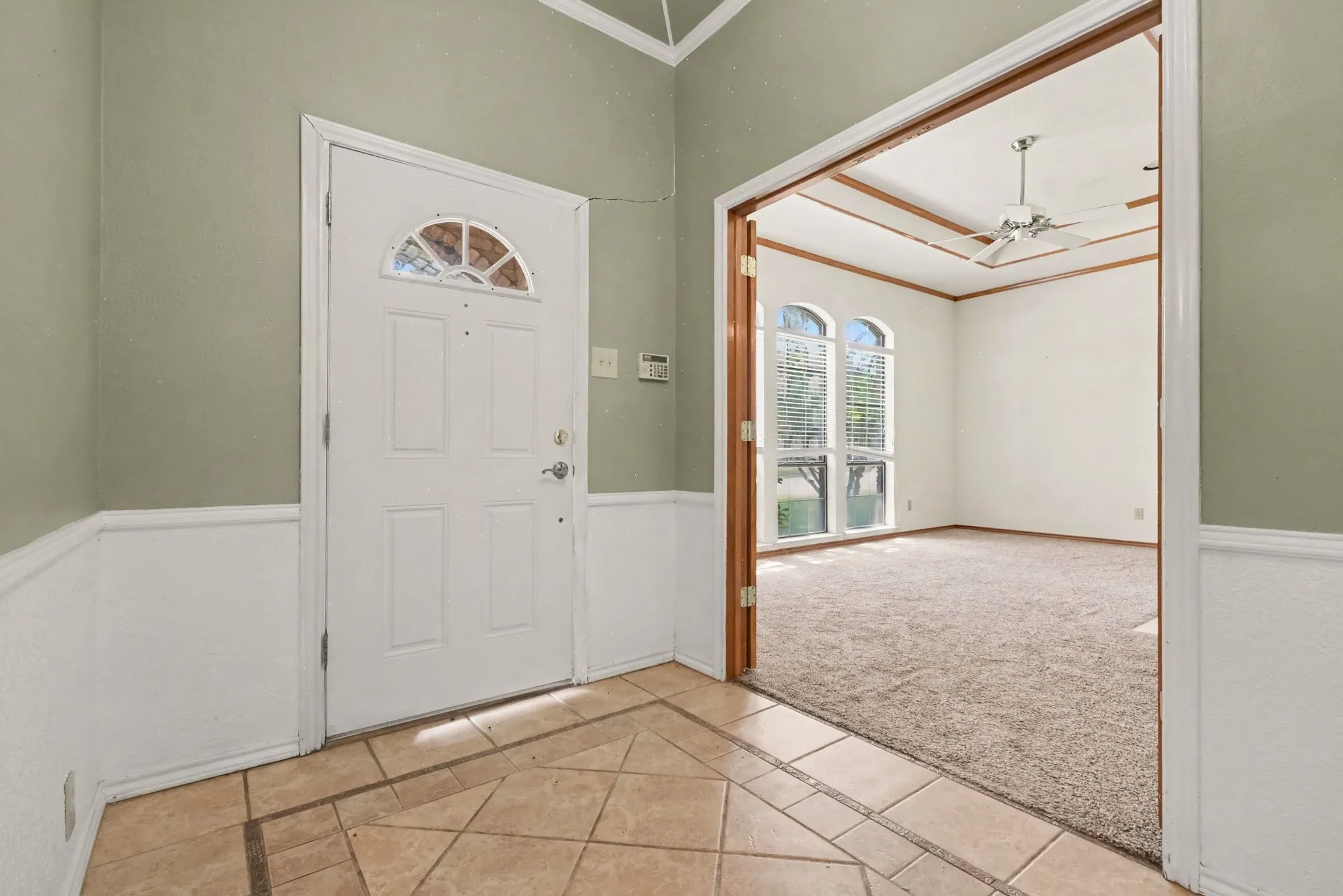 Tiled entry with wainscoting and a vaulted ceiling