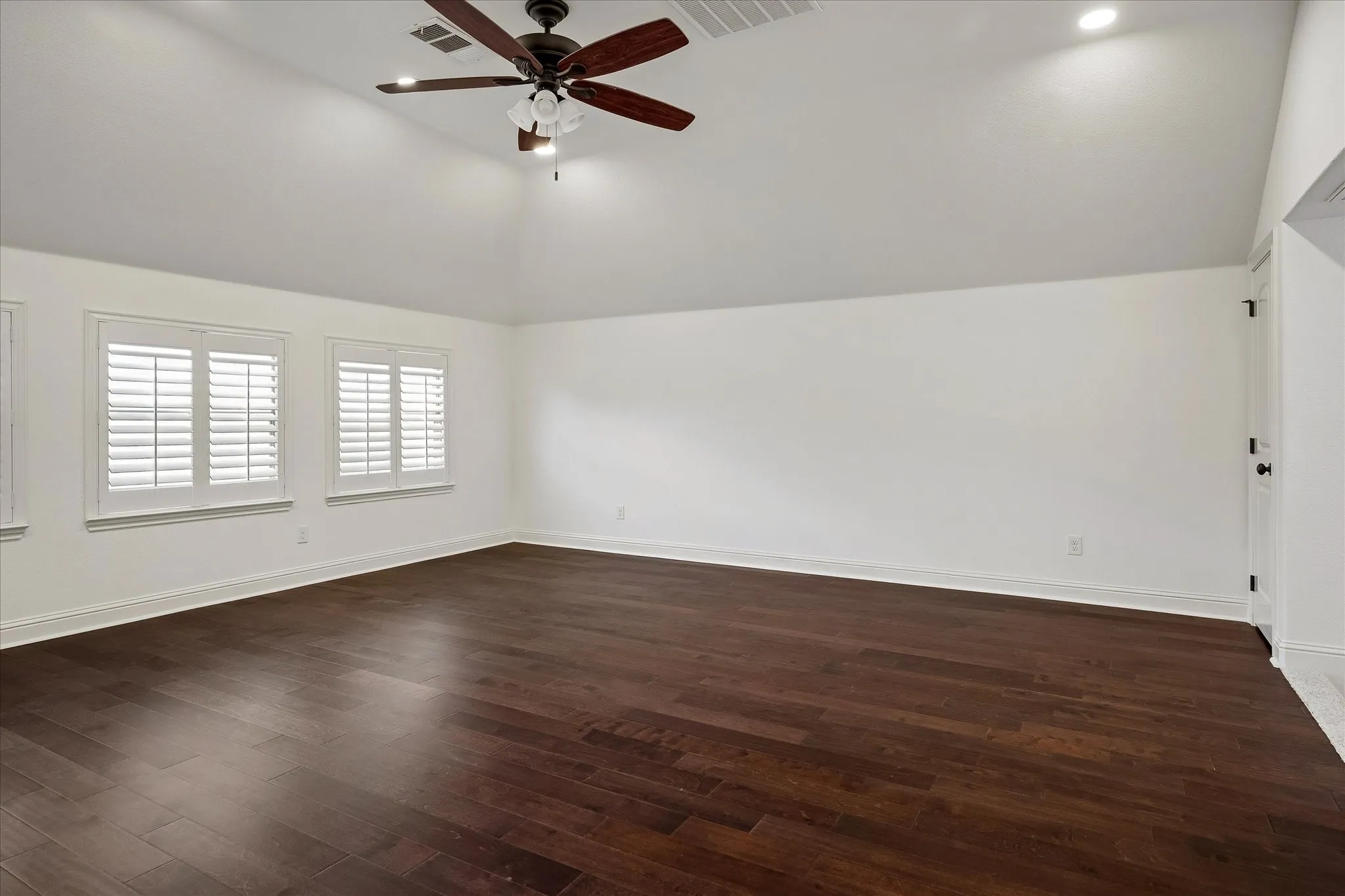 Spacious gameroom, upstairs living with wood type flooring, shutters, and great lighting.