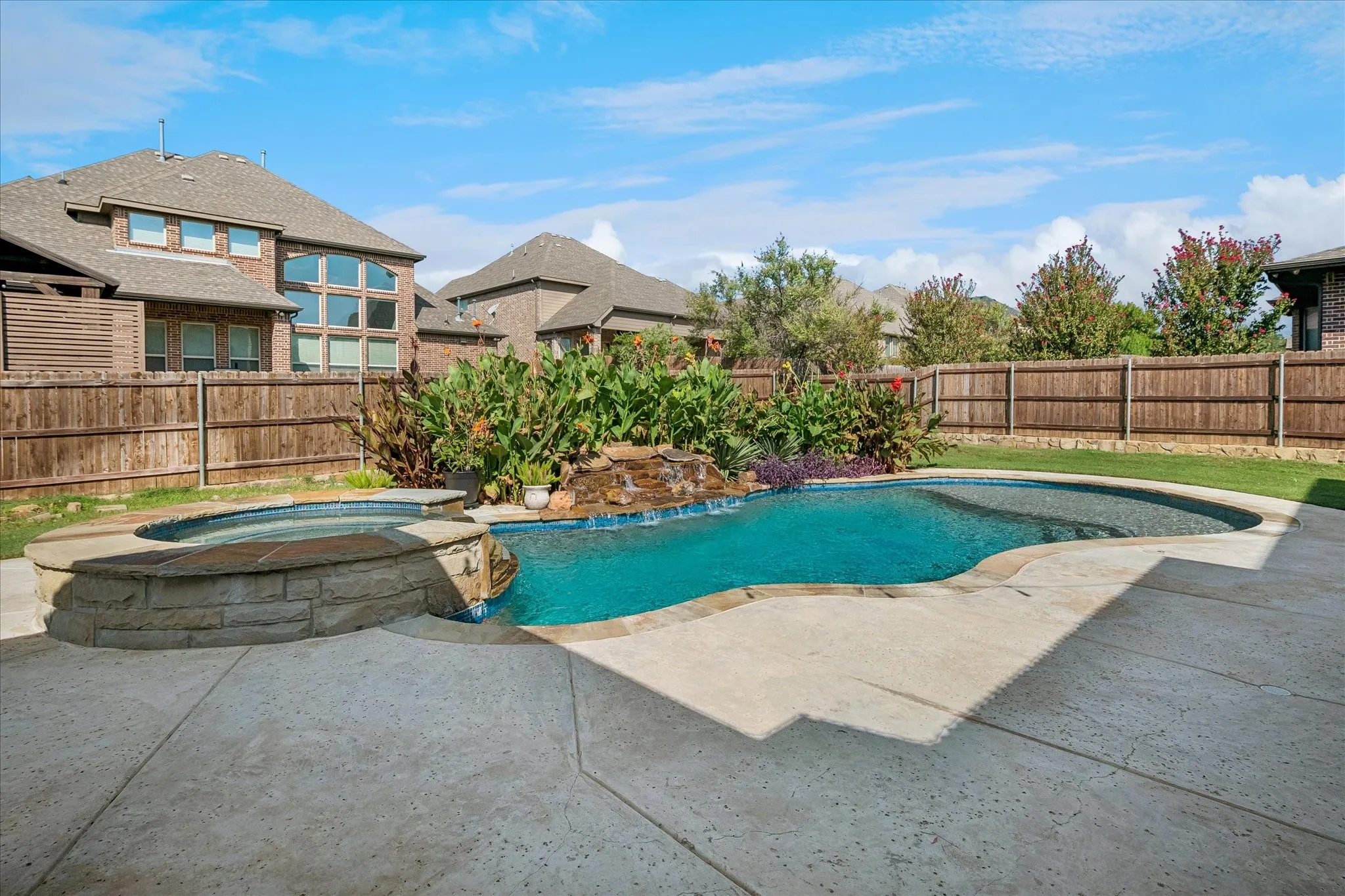 Pool with built in hot tub and water features.