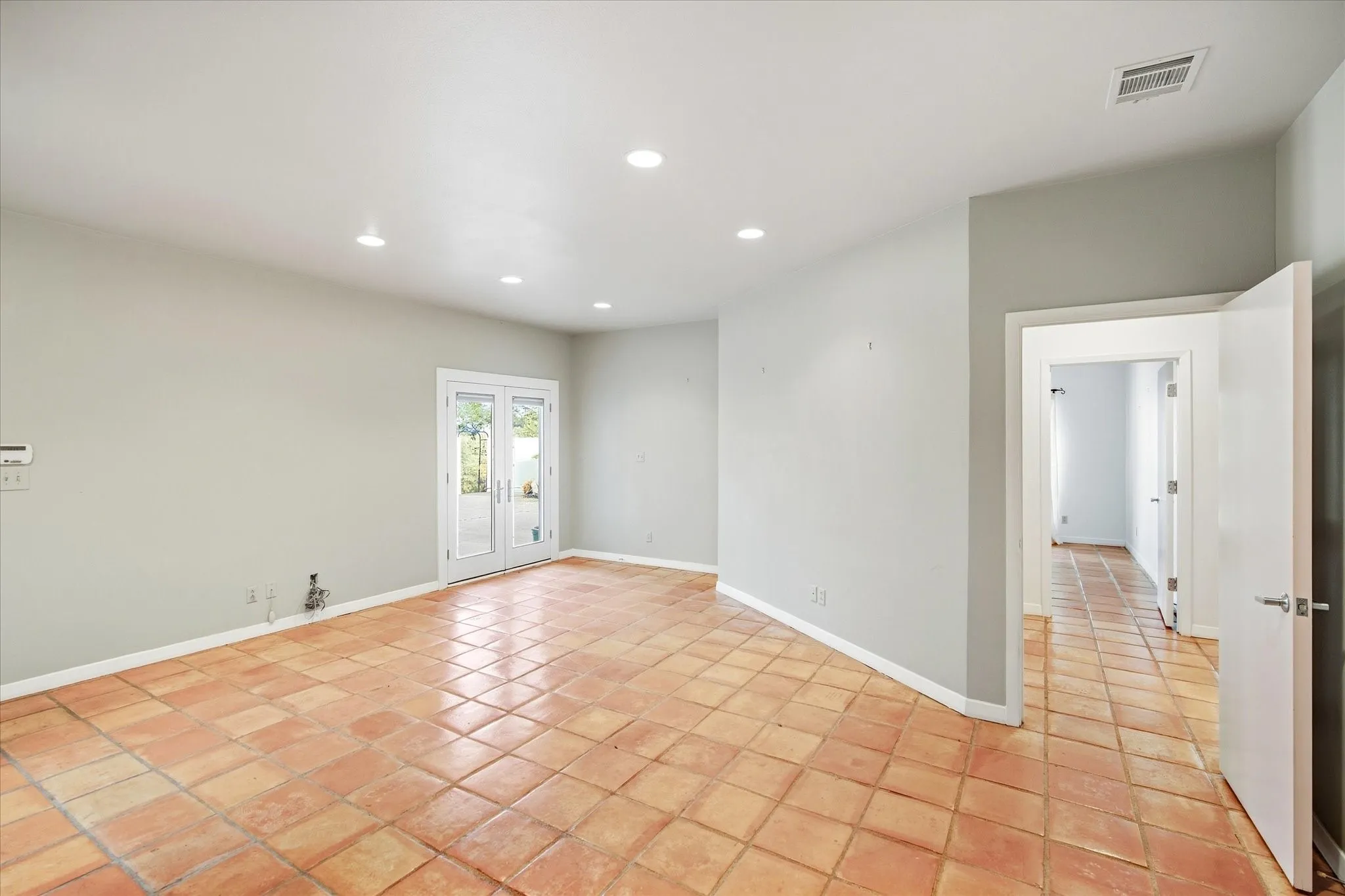 Terracotta tile flooring throughout with recessed lighting