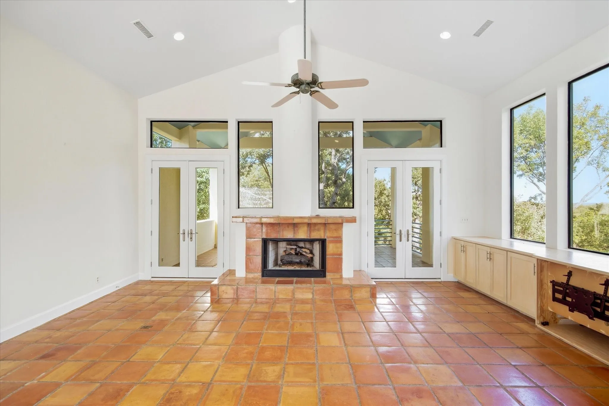 Vaulted ceilings, a tiled fireplace with hearth, and extensive built-in cabinetry