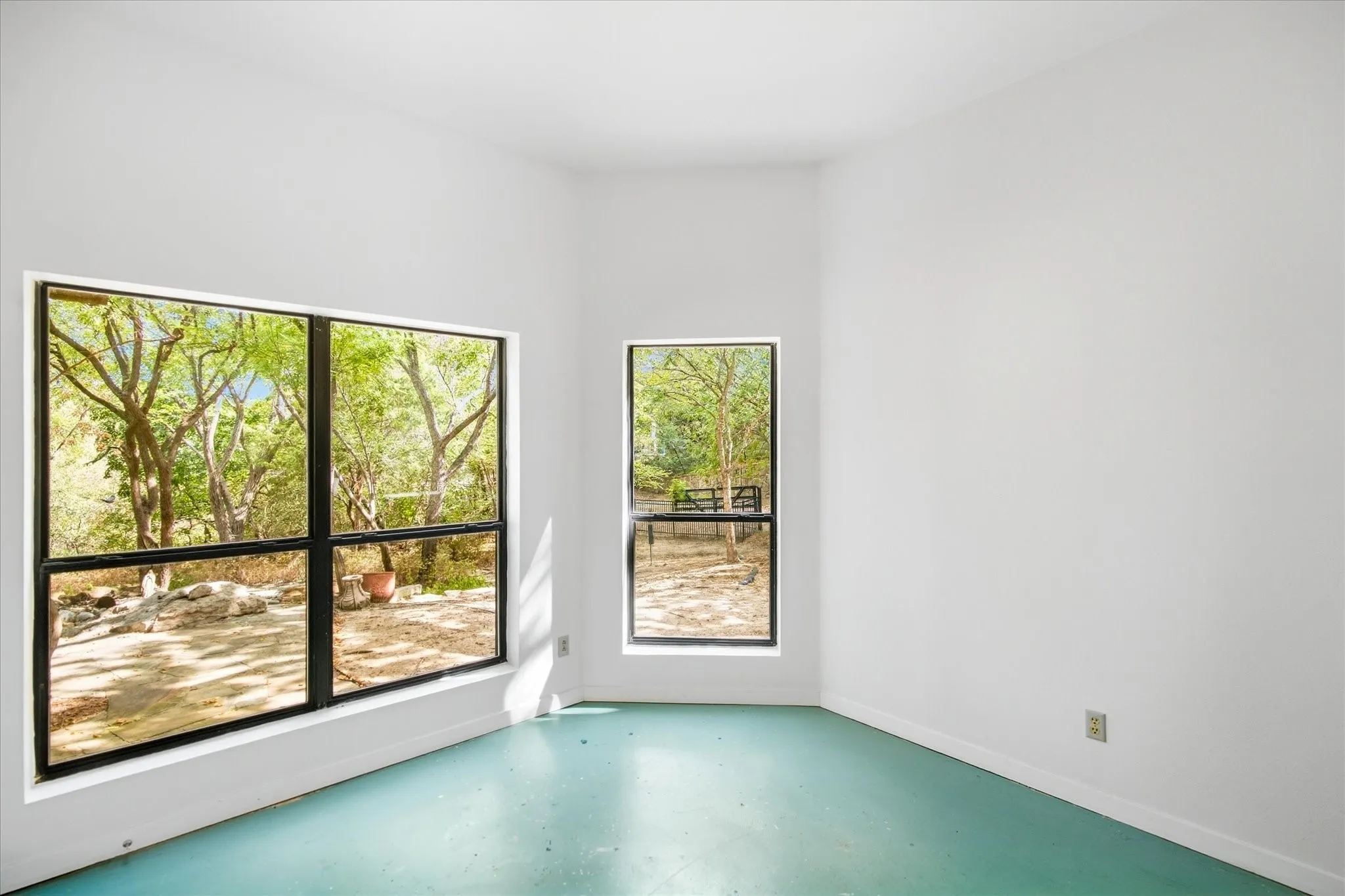 White walls, black-framed windows, and light blue flooring