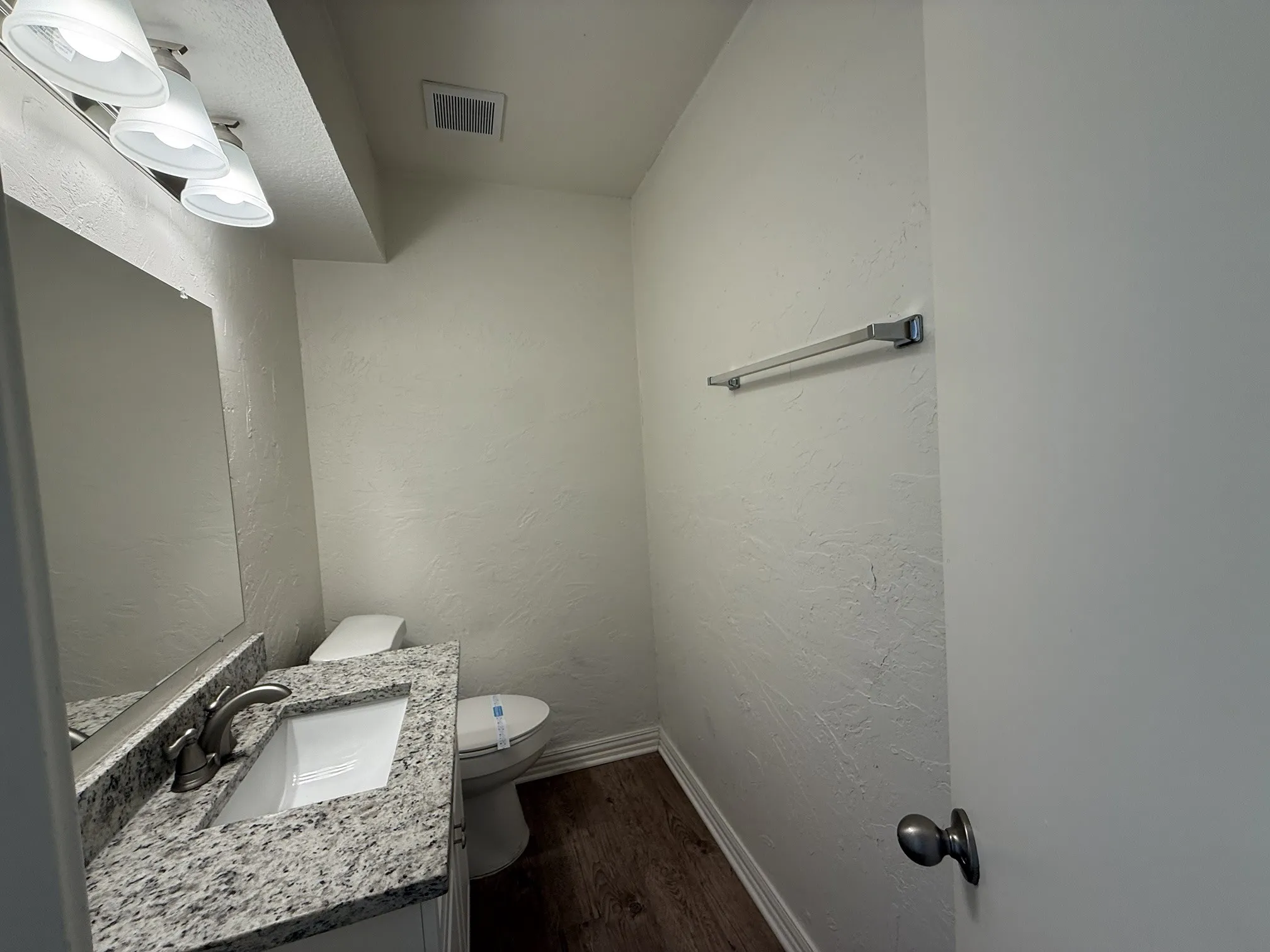 Vanity with a granite-style countertop, undermount sink, and brushed nickel faucet
