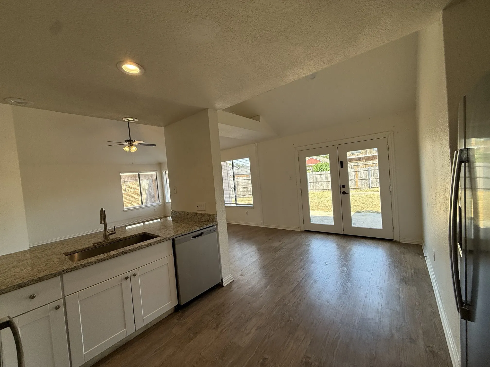 Kitchen featuring white cabinetry, granite countertops, stainless steel appliances, and a stainless steel sink with a gooseneck faucet