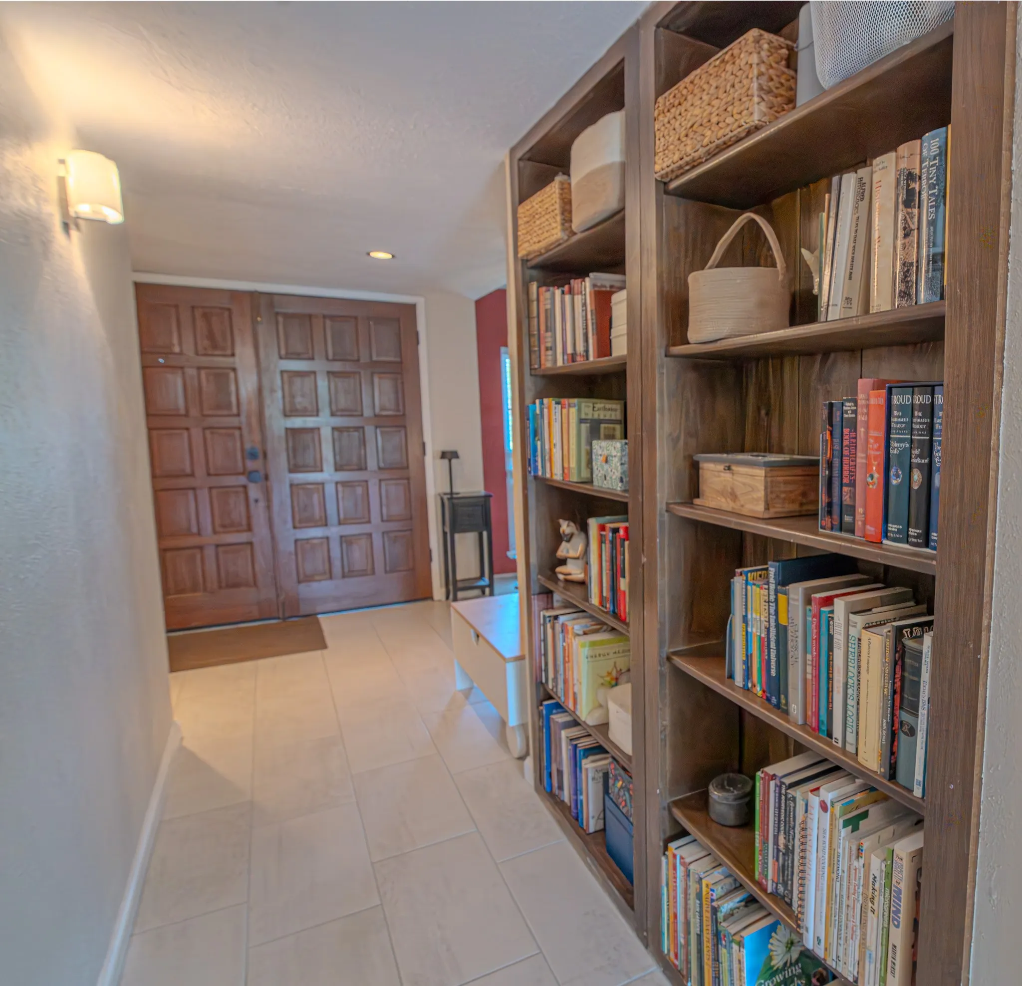 Double-panel entry door, integrated wall sconce, recessed ceiling lighting, tile flooring, and built-in shelving