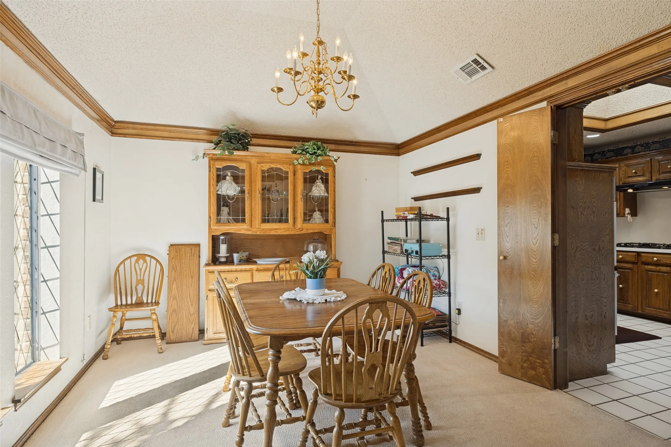 Recessed ceiling with an ornate chandelier and wood-finish trim accents