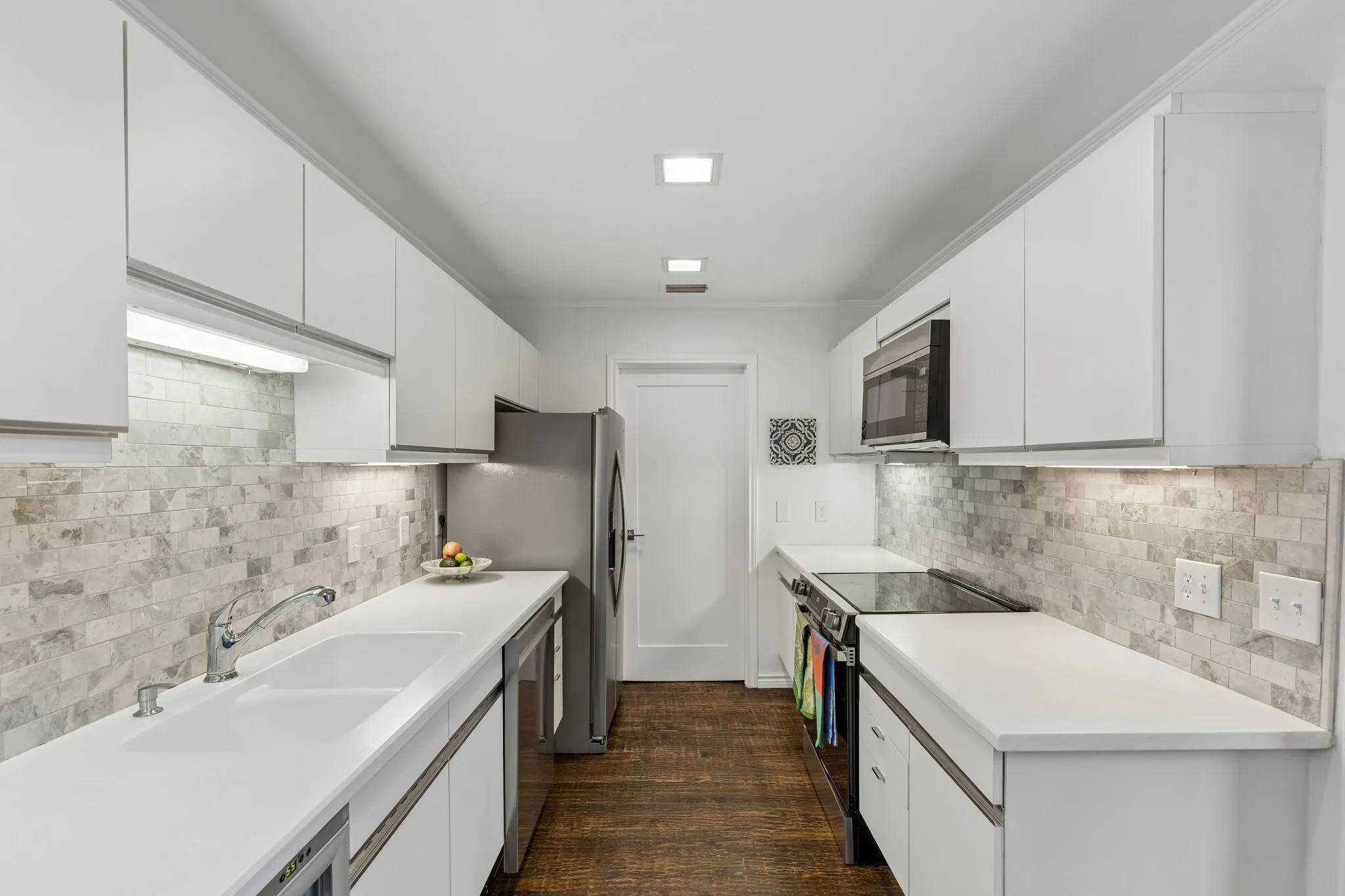 View into the kitchen with marble backsplash and solid surface counter tops