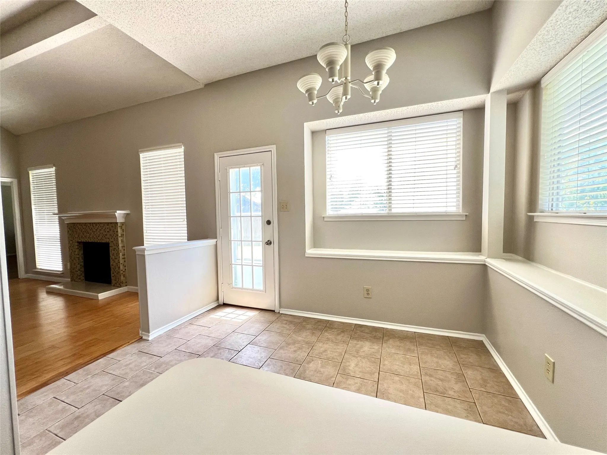 Entryway with tile patterned floors, baseboards, a chandelier, and a fireplace with raised hearth