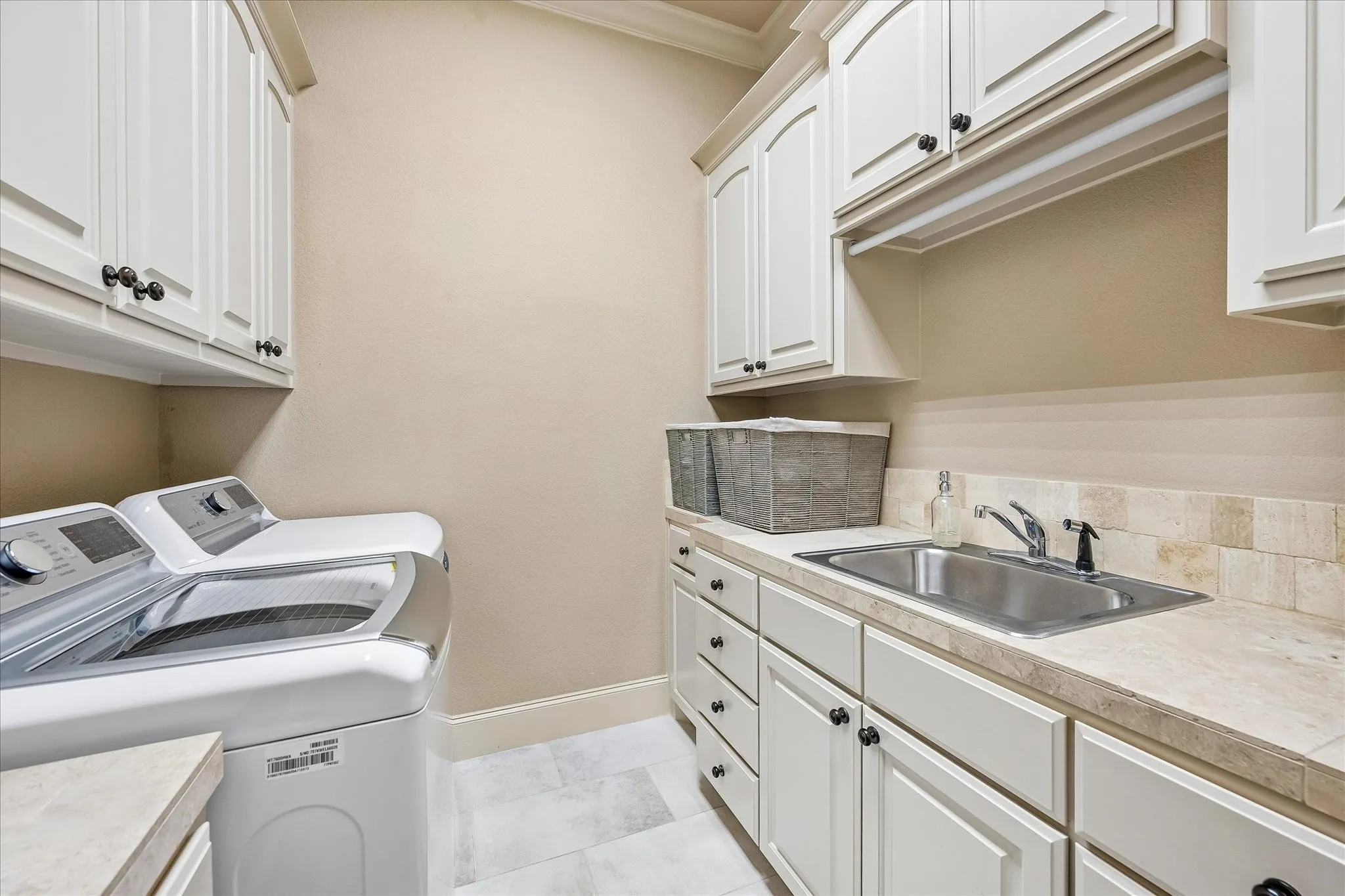 First floor laundry room with sink and abundant storage.