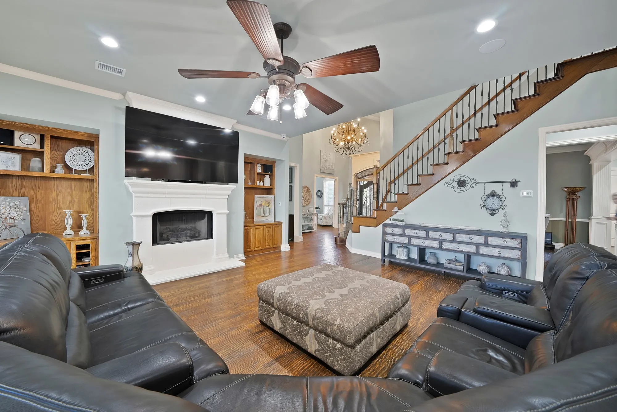 A warm and inviting living space creates the perfect setting for gatherings, complemented by a wall of windows that fills the room with natural light and offers beautiful views of the outdoors.
