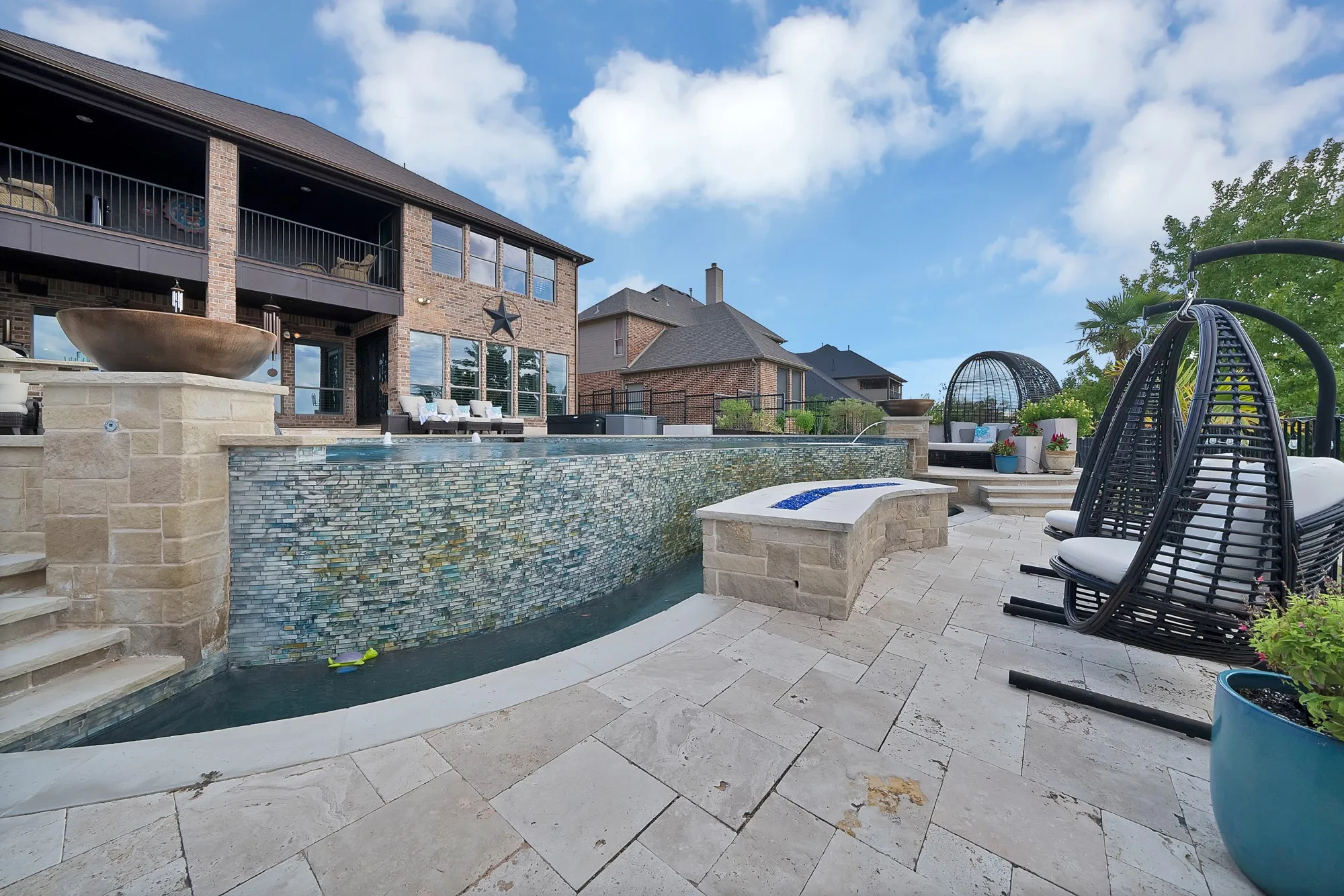 A dramatic fire wall feature adds warmth and ambiance, creating the perfect backdrop for quiet evenings spent relaxing and enjoying the peaceful outdoor setting.
