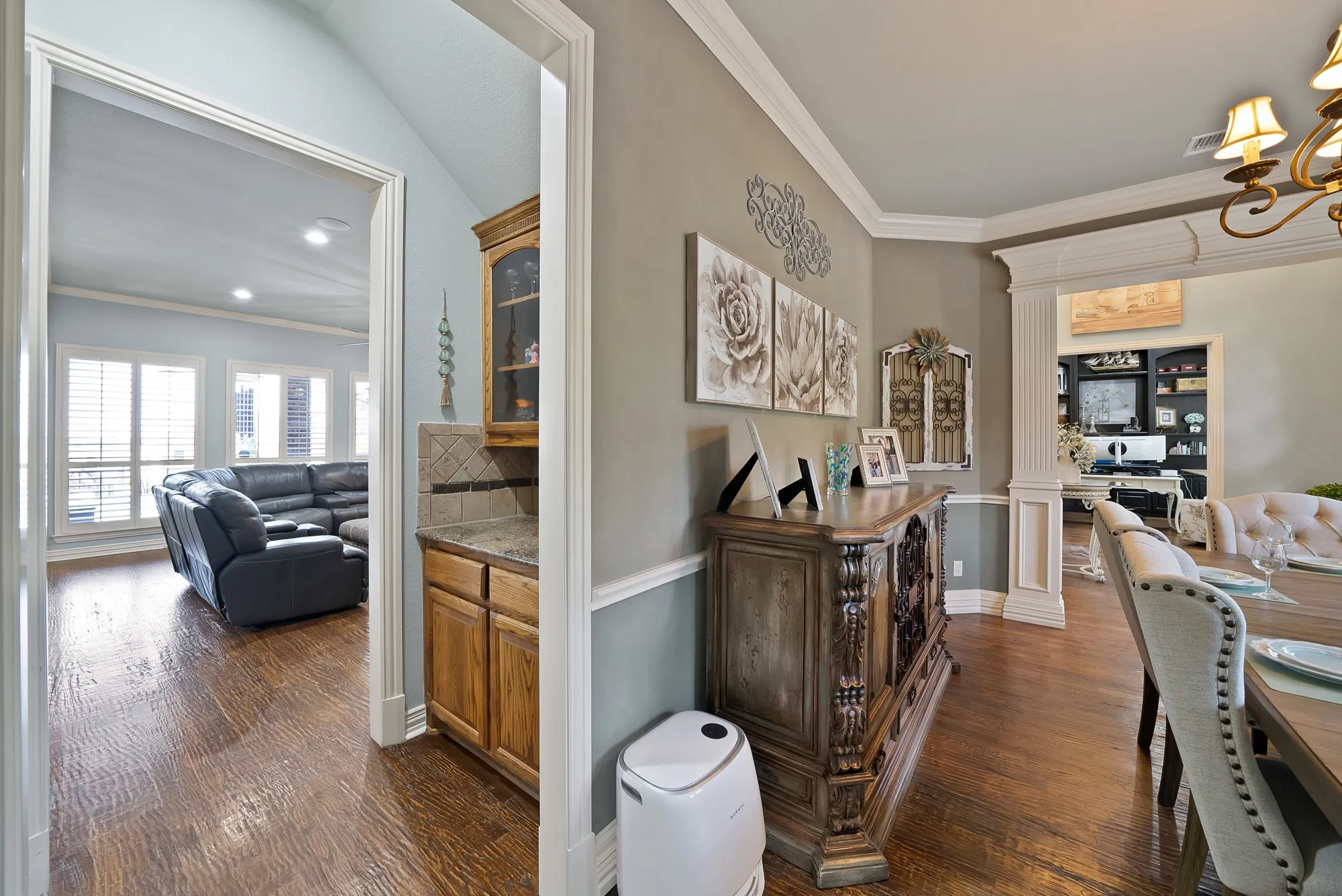 The wine or coffee bar is thoughtfully positioned directly off of kitchen and between the formal dining room and living area, offering effortless functionality for entertaining.
