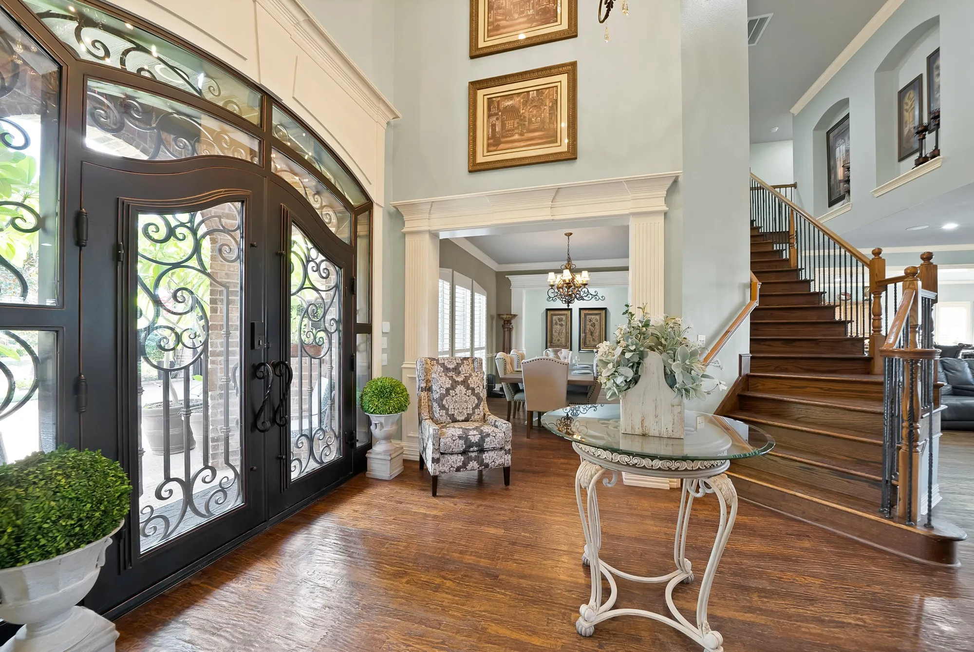 Grand and inviting foyer makes a stunning first impression, featuring beautifully crafted decorative doors that sets the tone for the exceptional elegance found throughout the home.