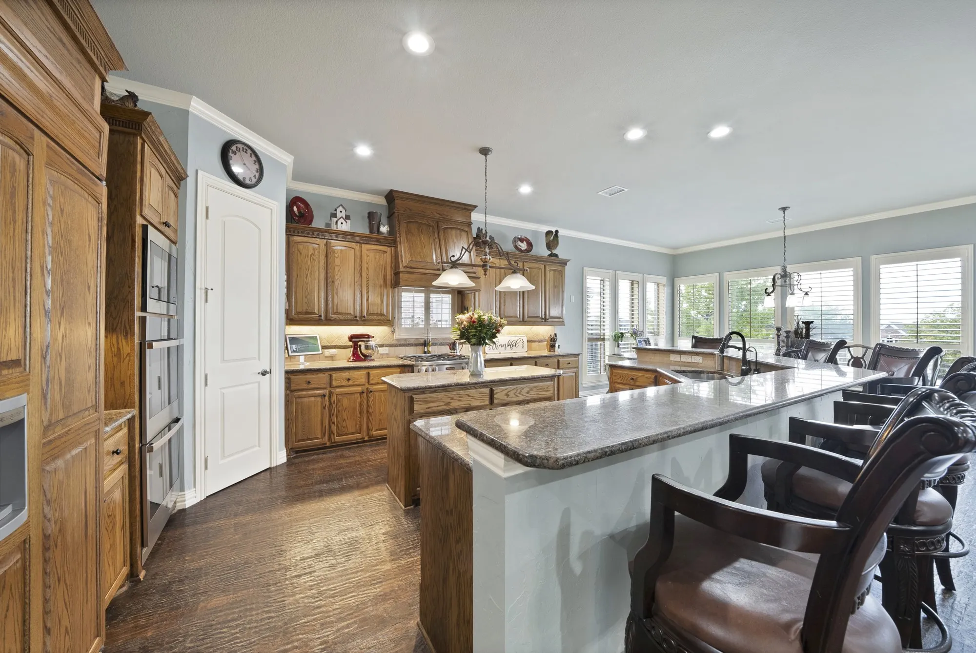 A truly impressive chef’s kitchen blends luxury and functionality, featuring an expansive island, abundant premium countertop space, built-in refrigerator, upgraded appliances, and an elevated bar with generous seating.