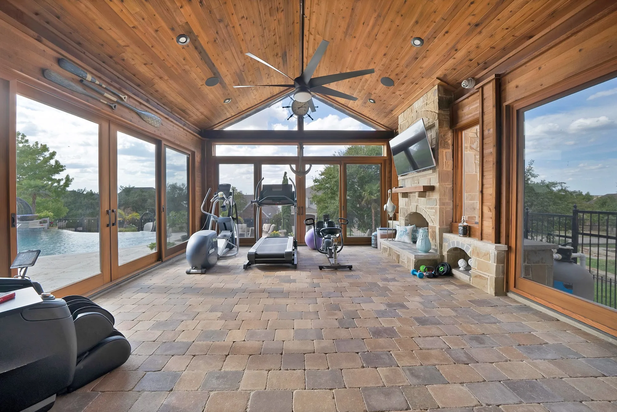 Complete with a cozy fireplace and expansive glass that opens to the outdoors, this versatile retreat is the perfect place to relax and unwind, seamlessly blending indoor comfort with the beauty of nature.

