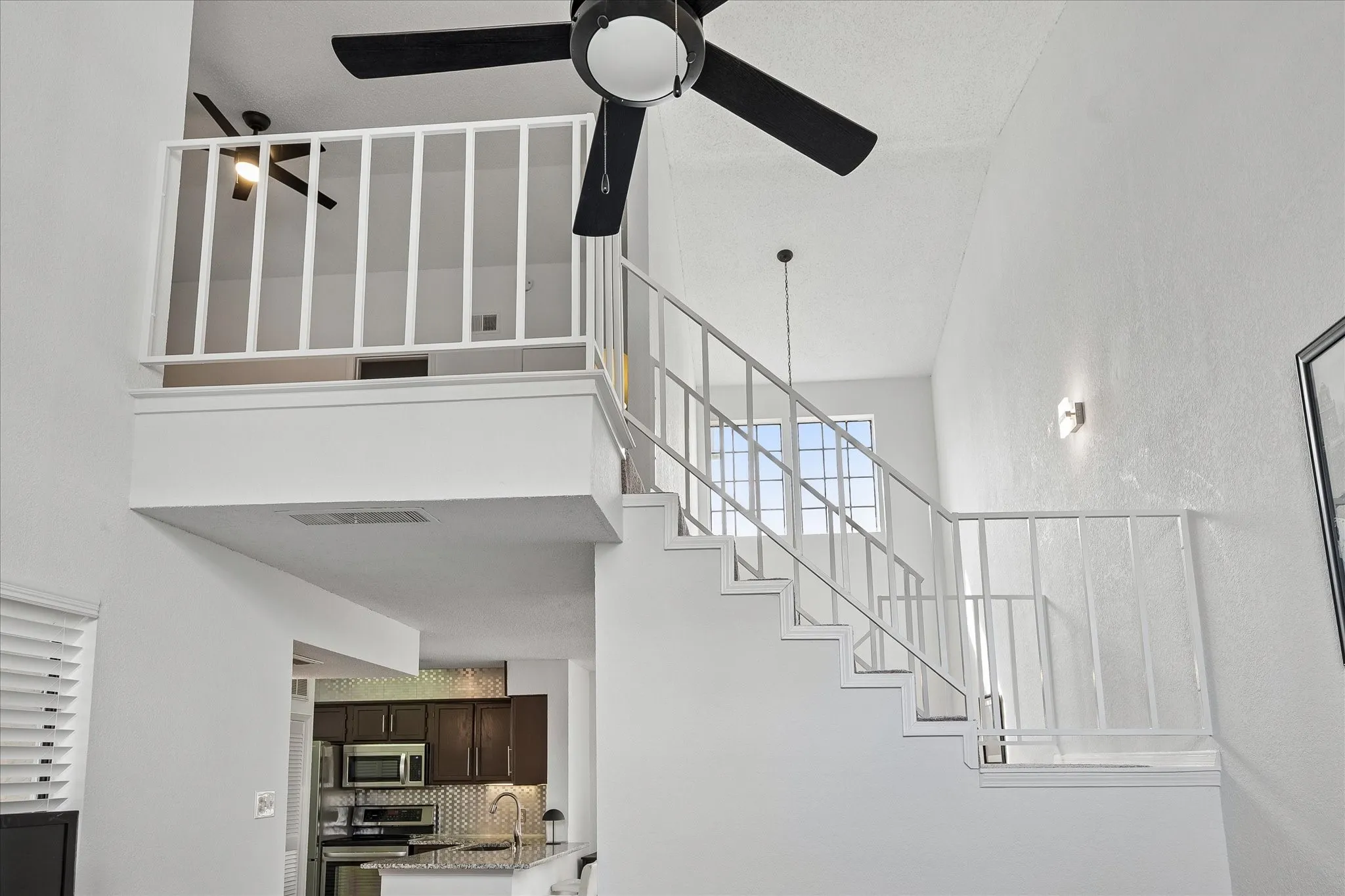 Stairway view from living area. Primary bedroom is lofted and overlooks the living area.