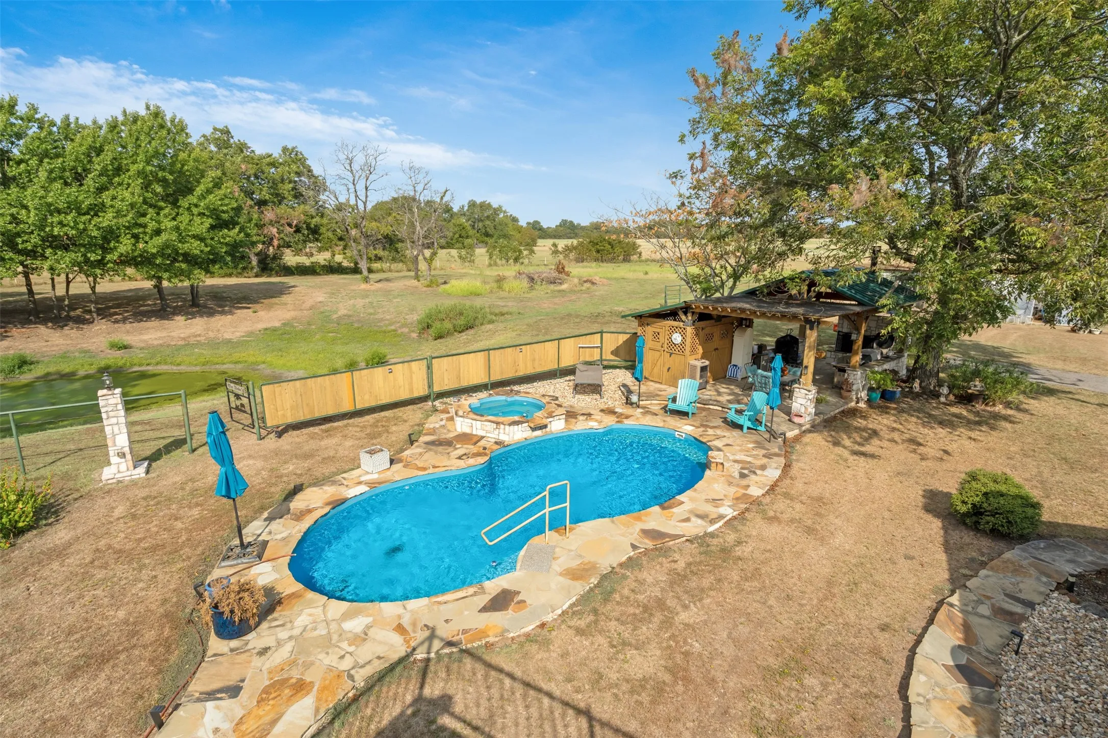 Freeform swimming pool with integrated spa and natural stone coping