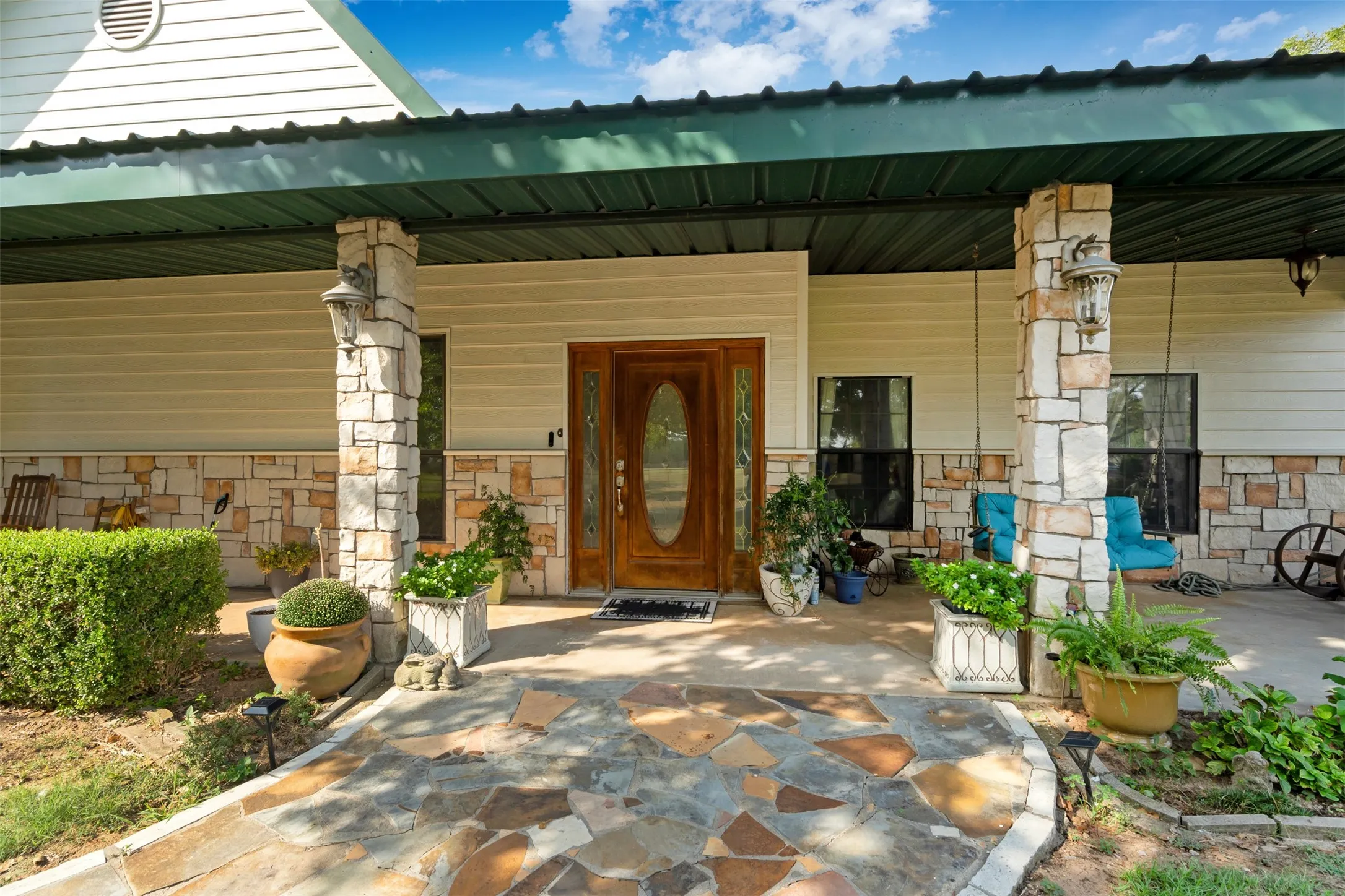 Stone veneer accents the exterior with a wood-panel entry door and sidelight
