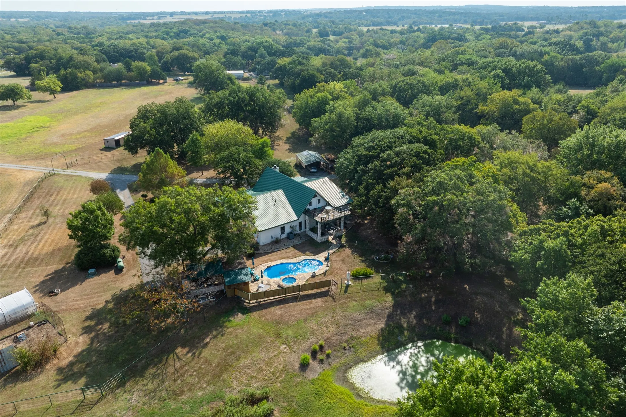Expansive property featuring a residence with a green roof, a private swimming pool, and a pond