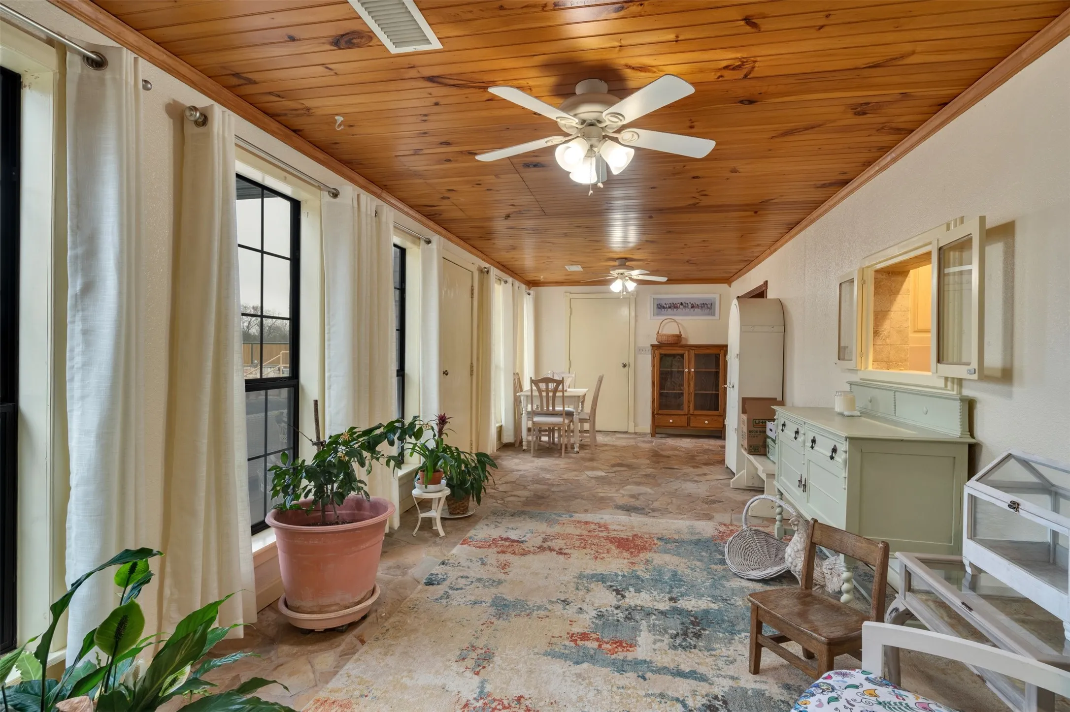 Wood-paneled ceiling with ceiling fans and recessed lighting