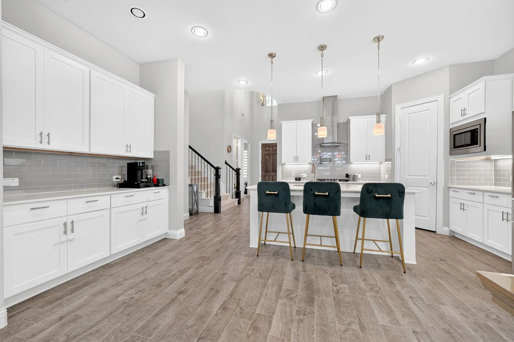 Gourmet kitchen featuring white cabinetry, light-toned countertops, and a subway tile backsplash