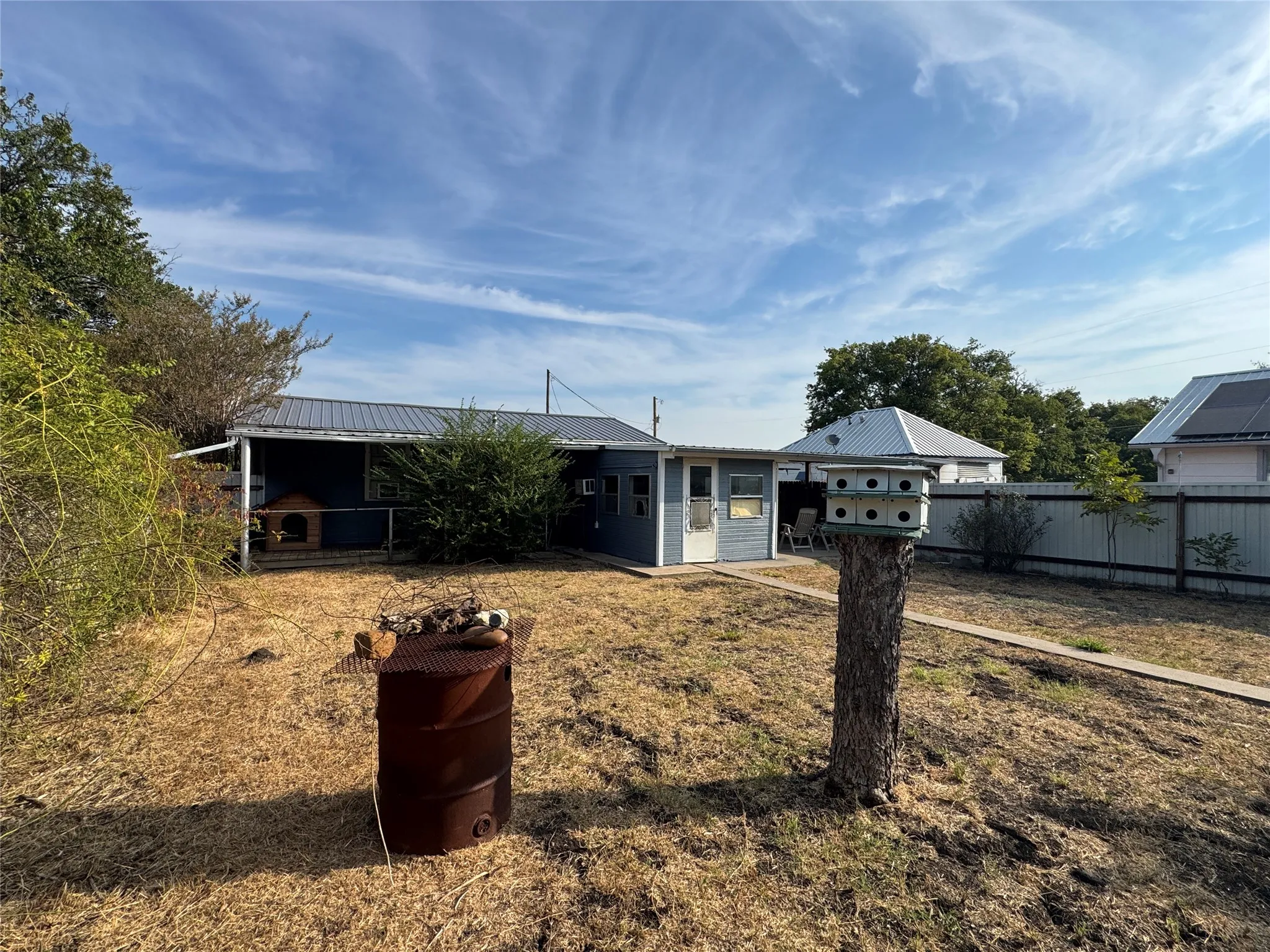 Private backyard space featuring a covered patio, detached structure, and perimeter fencing
