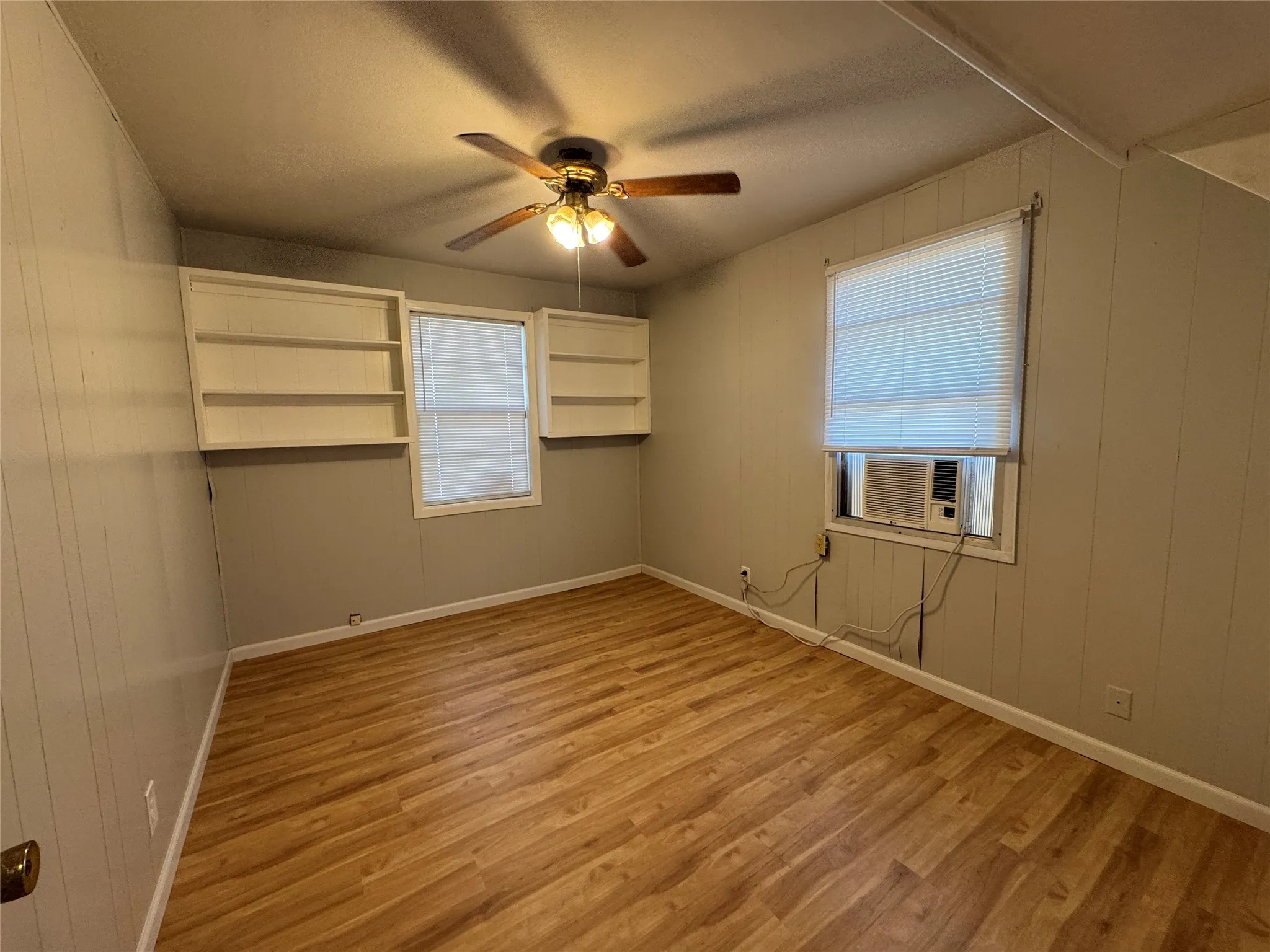 Wood-finish flooring with a ceiling fan light fixture