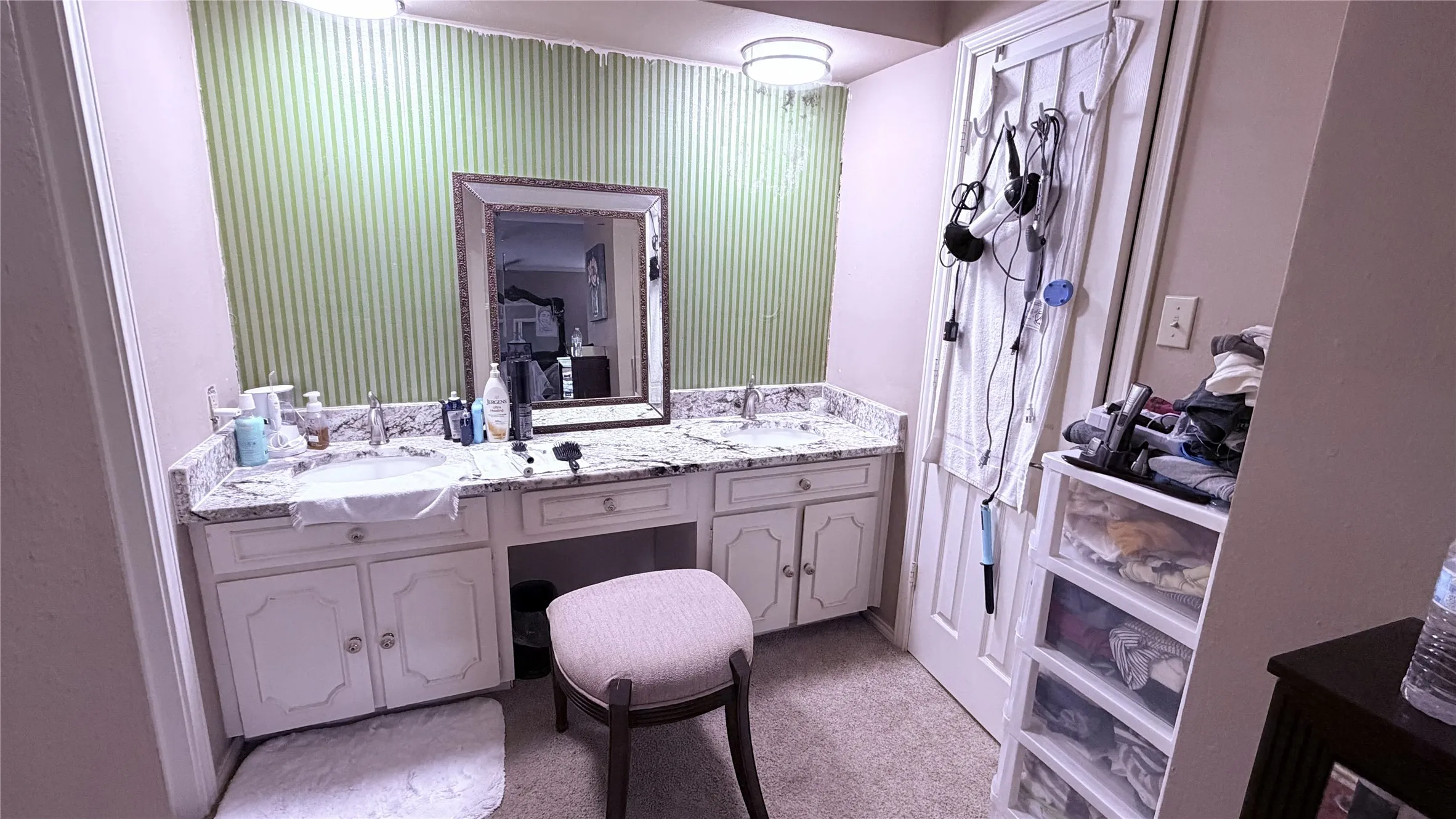 Dual basin vanity with stone-finish countertop, undermount sinks, and built-in cabinetry