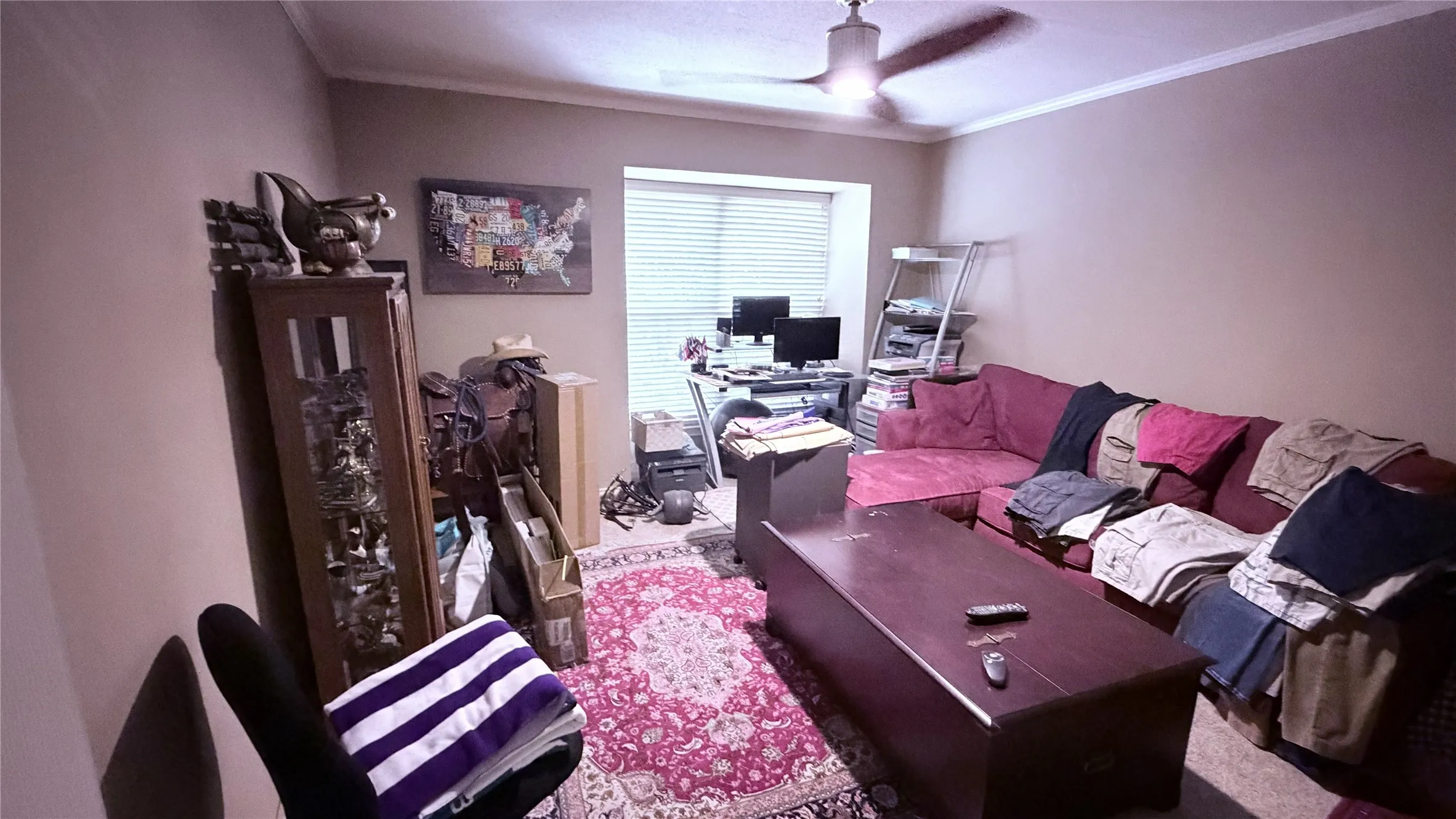 Window with blinds, wall-mounted ceiling fan, and carpeted flooring