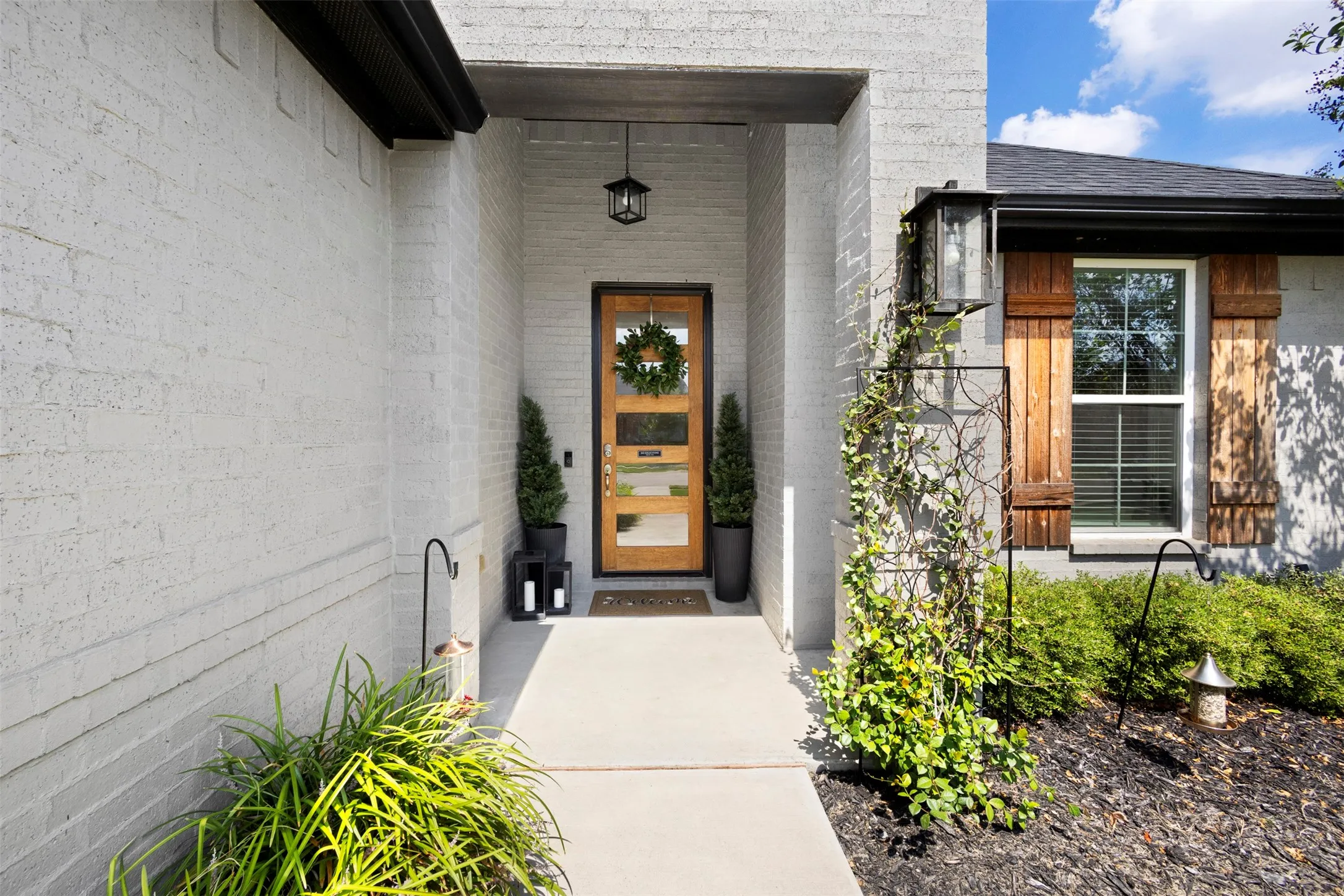 The ornate front door complements the painted brick so well!