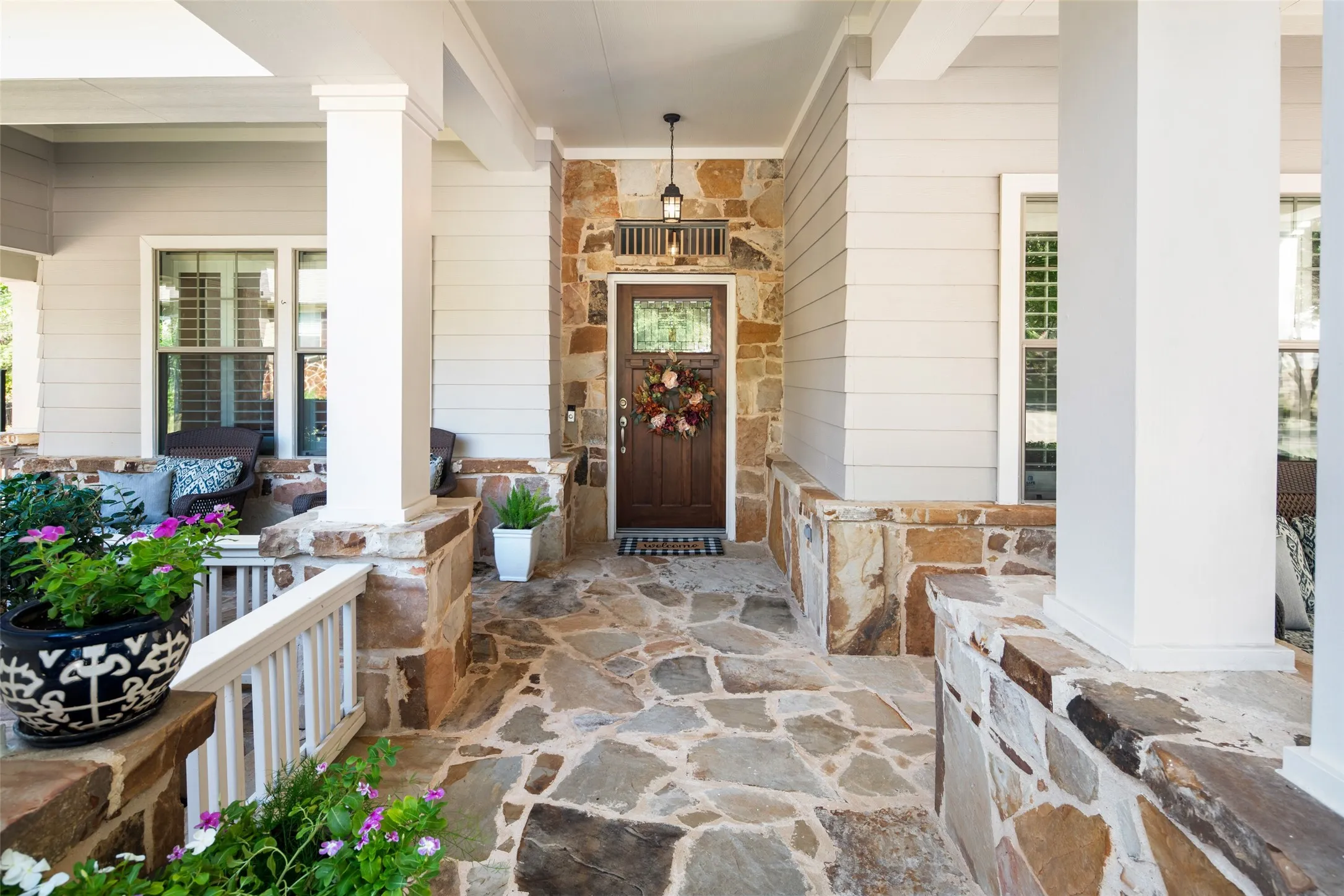 Expansive Covered Front Porch Area with two seating areas and the perfect spot to relax!  And there's more...This gorgeous flagstone patio wraps around THREE sides of this beautiful home.