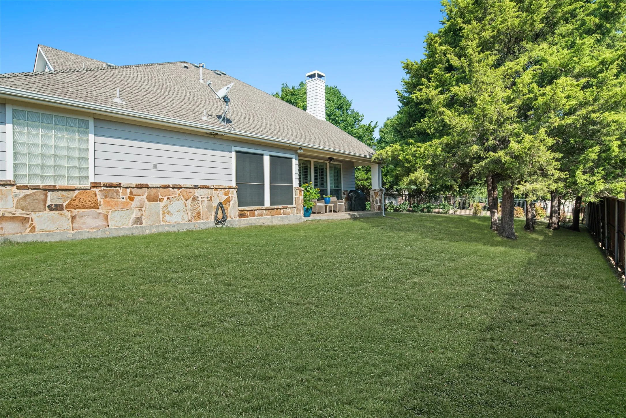 View of Backyard and Covered Patio adjacent to Living Area. Some items virtually staged.